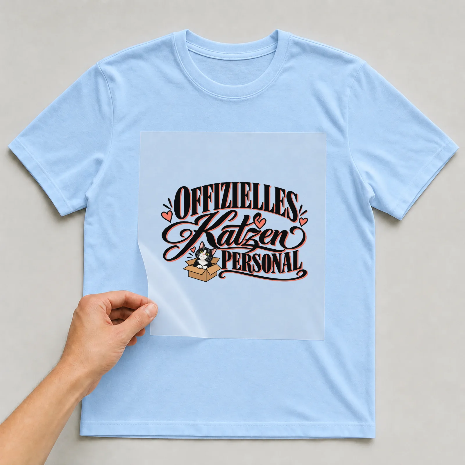 Bügelbild „Offizielles Katzenpersonal“ auf hellblauem T-Shirt, Folie wird aufgelegt
