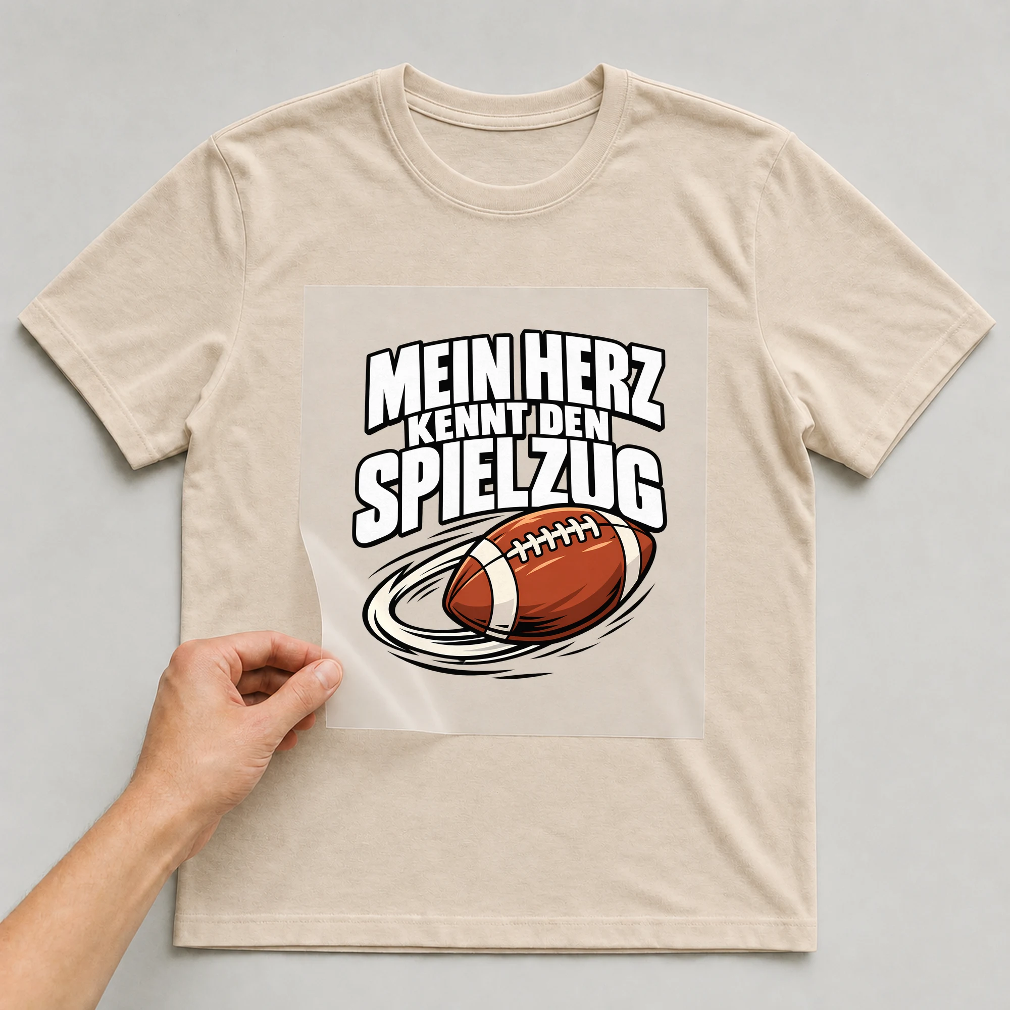 Bügelbild „Mein Herz kennt den Spielzug“ auf beigem T-Shirt, Folie wird aufgelegt