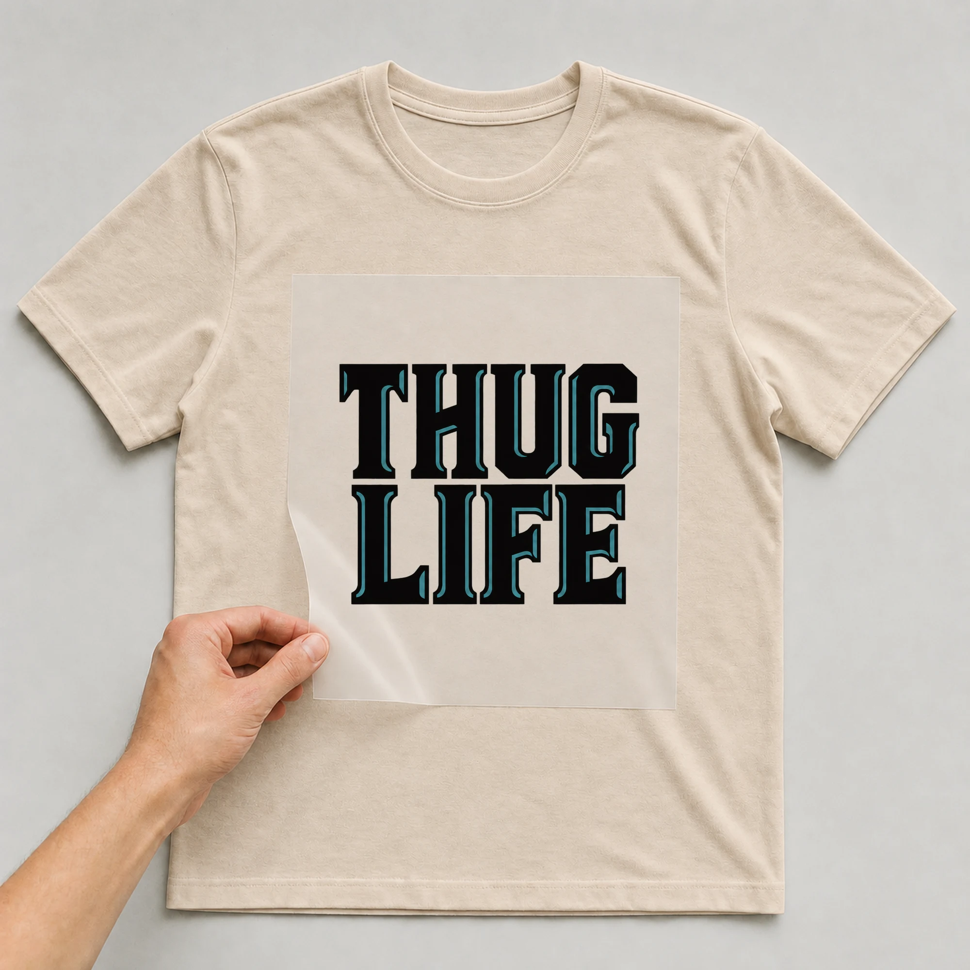 Bügelbild „Thug Life“ auf beigem T-Shirt, Folie wird aufgelegt
