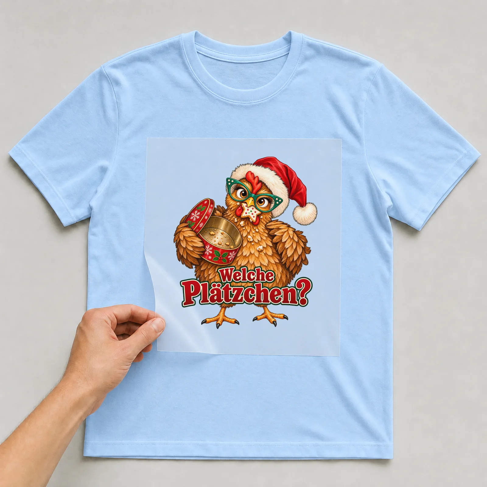Bügelbild huhn plaetzchendieb auf hellblauem T-Shirt, Folie wird aufgelegt