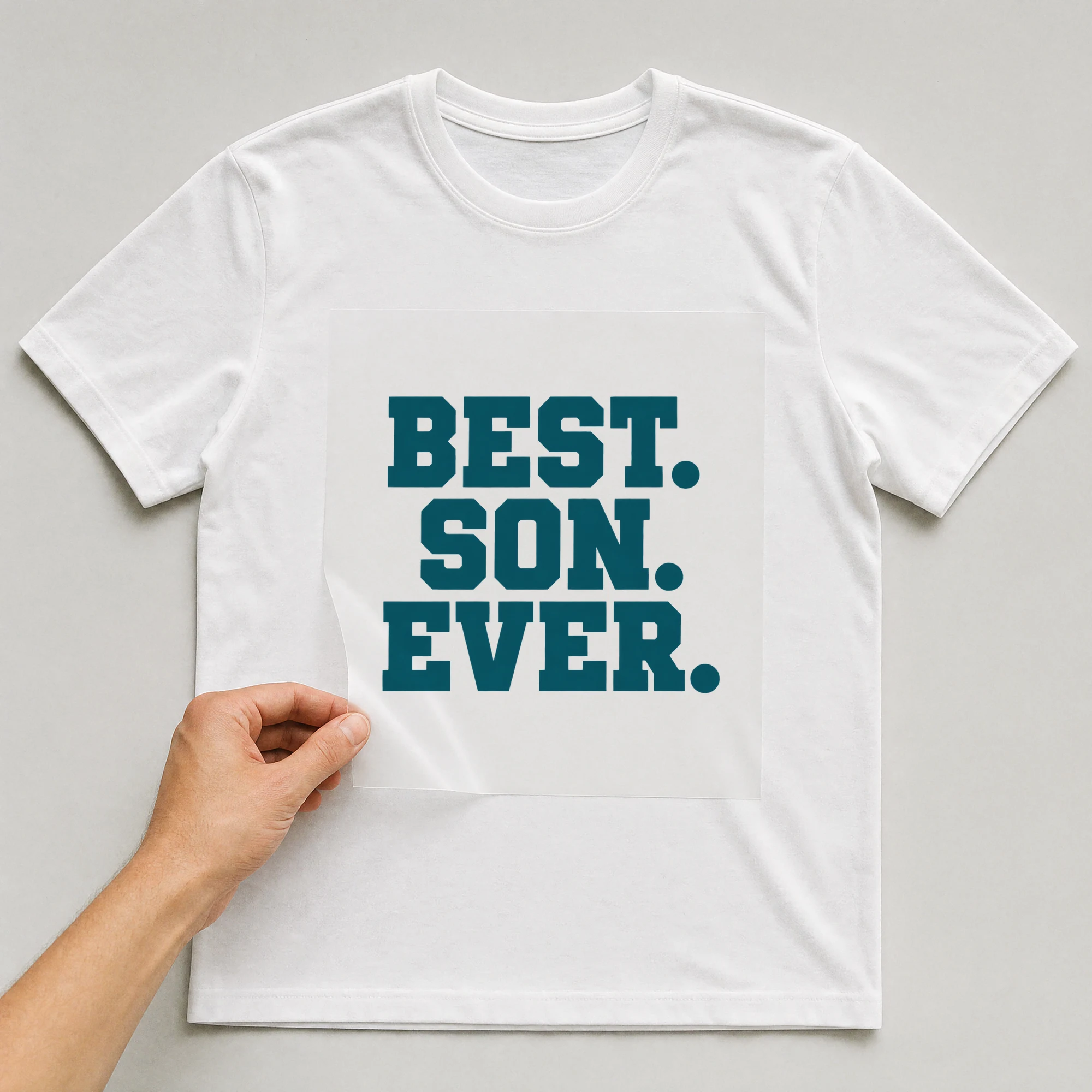 Bügelbild „Best. Son. Ever.“ auf weißem T-Shirt, Folie wird aufgelegt