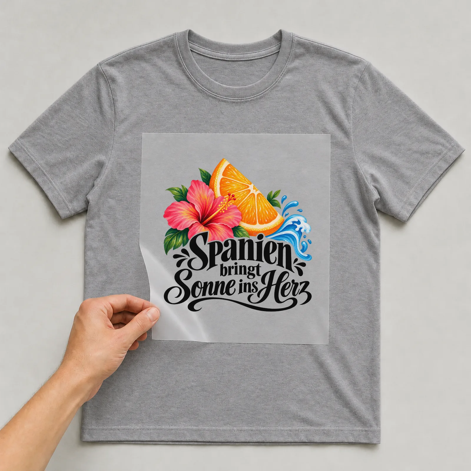Bügelbild „Spanien bringt Sonne ins Herz“ auf grauem T-Shirt, Folie wird aufgelegt