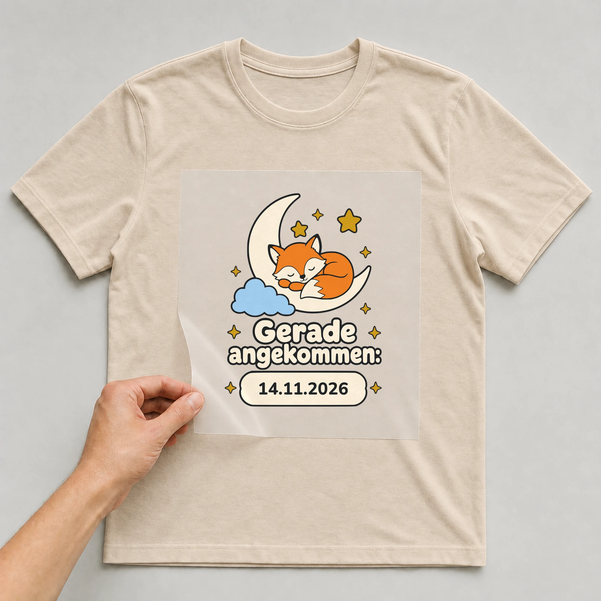 Bügelbild Gerade angekommen mit Datum auf beigem T-Shirt, Folie wird aufgelegt