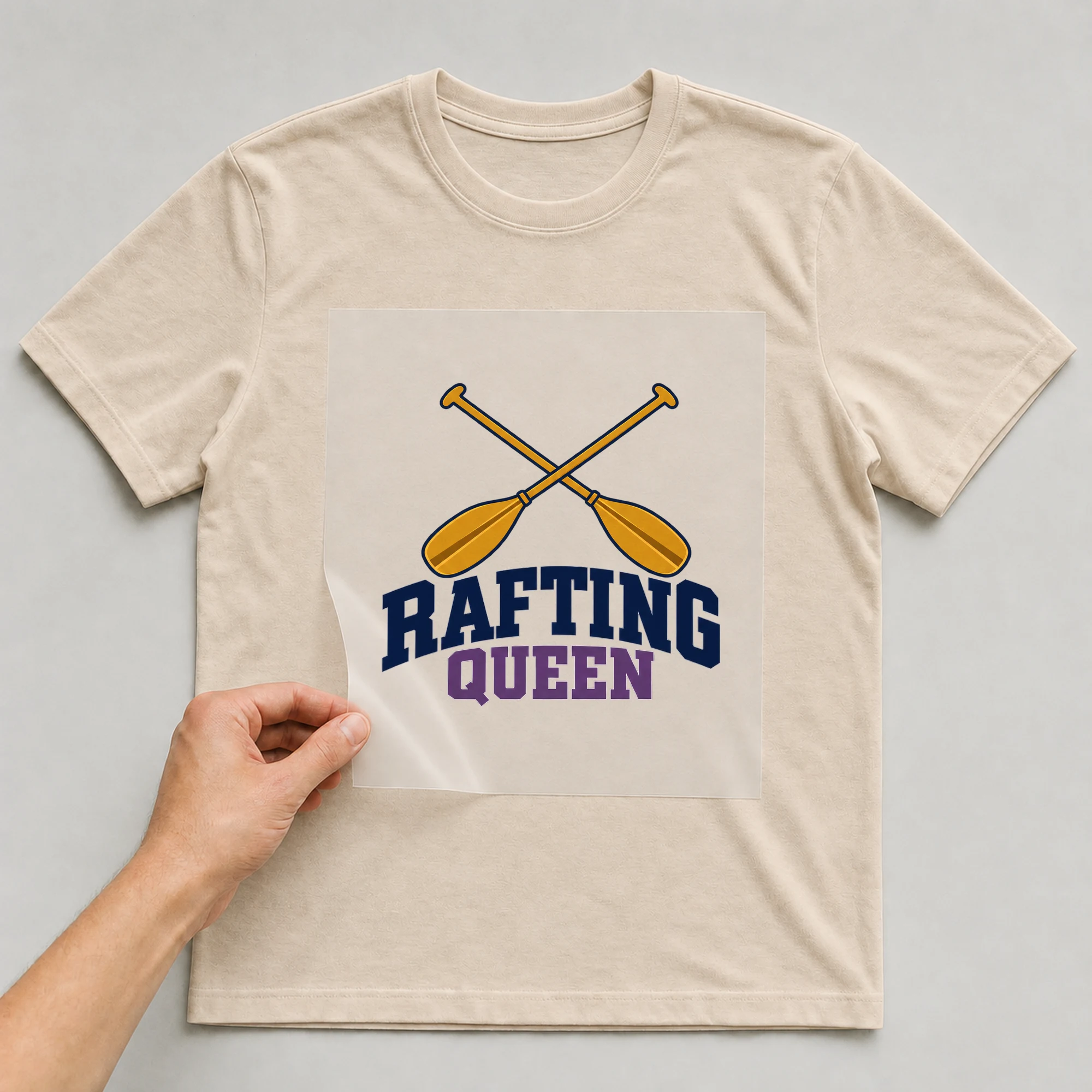 Bügelbild „Rafting Queen“ auf beigem T-Shirt, Folie wird aufgelegt