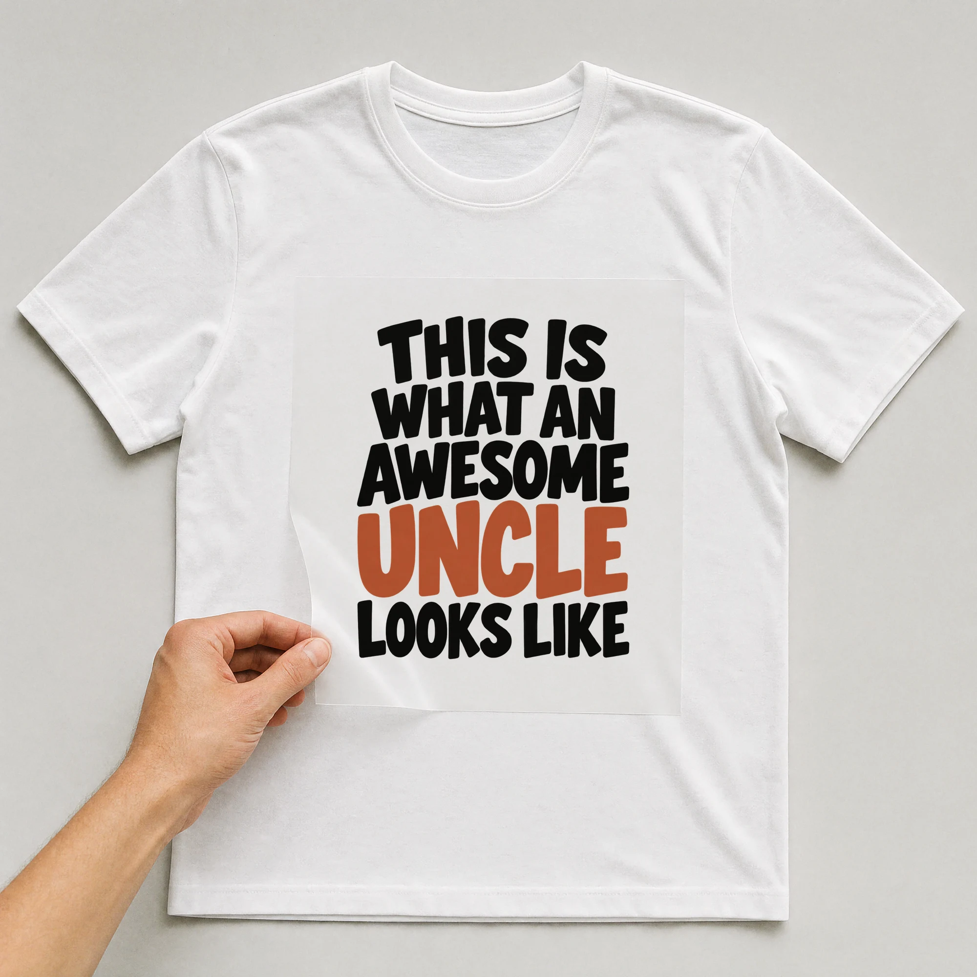 Bügelbild „This Is What An Awesome Uncle Looks Like“ auf weißem T-Shirt, Folie wird aufgelegt