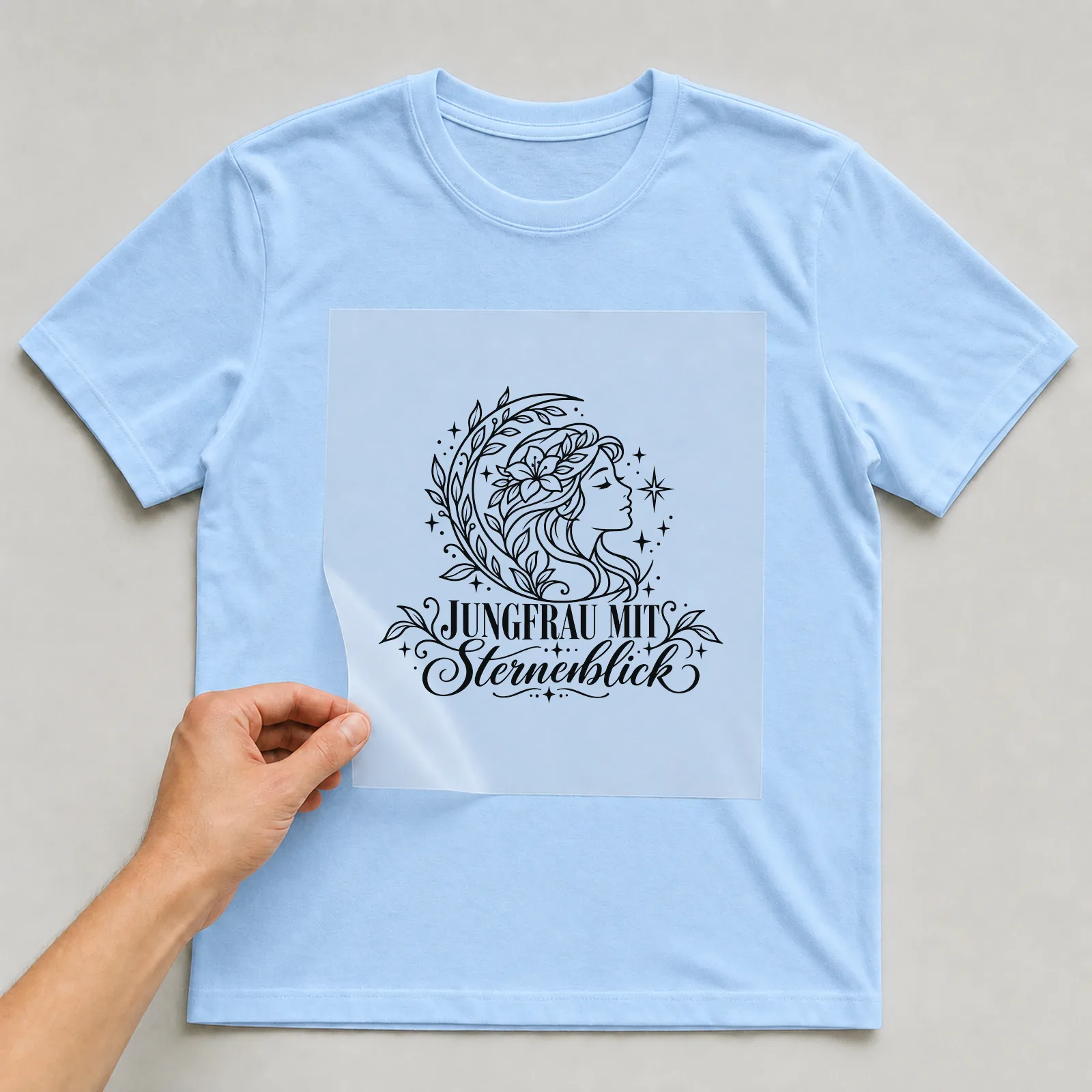 Bügelbild „Jungfrau mit Sternenblick“ auf hellblauem T-Shirt, Folie wird aufgelegt