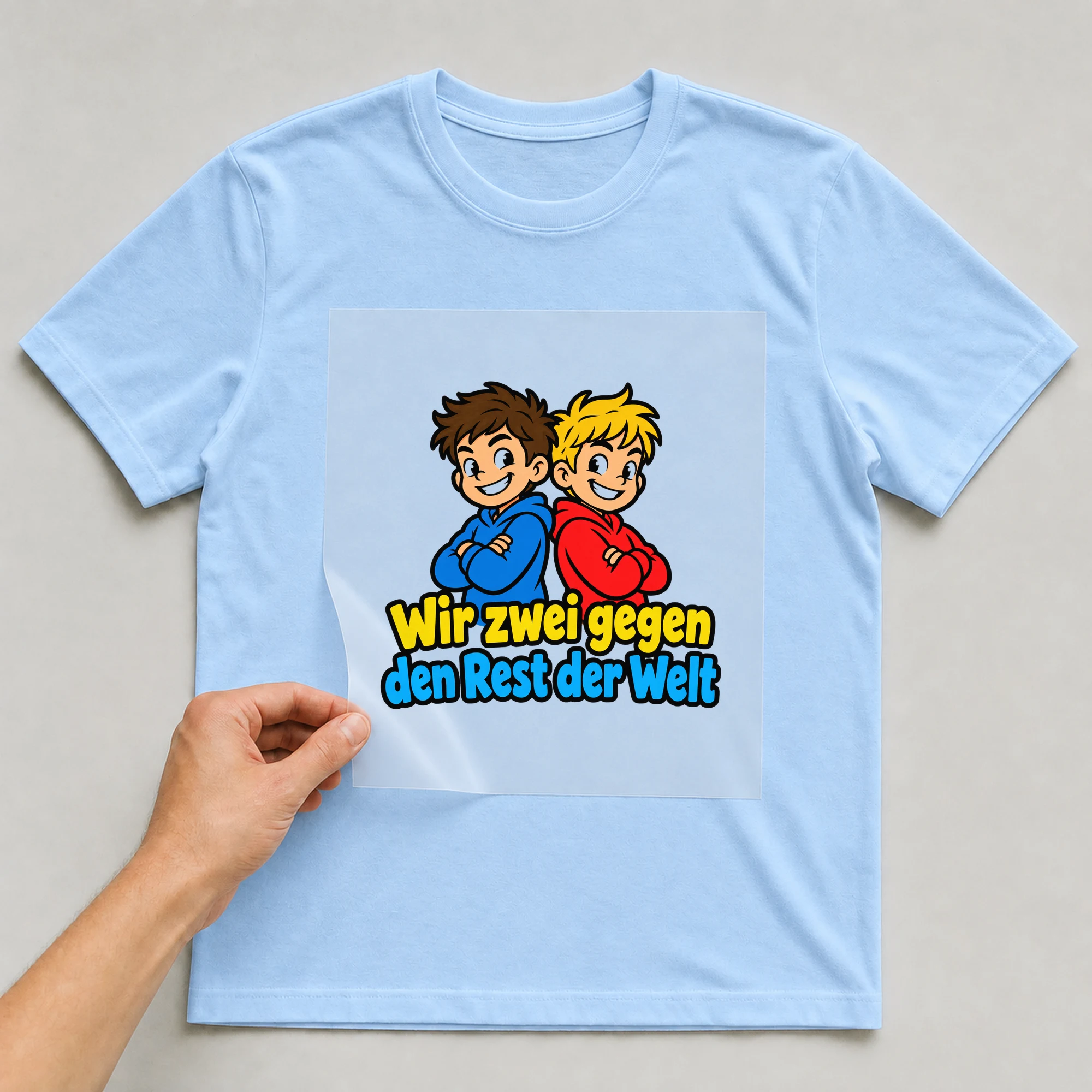 Bügelbild „Wir zwei gegen den Rest der Welt“ auf babyblauem T-Shirt, Folie wird aufgelegt