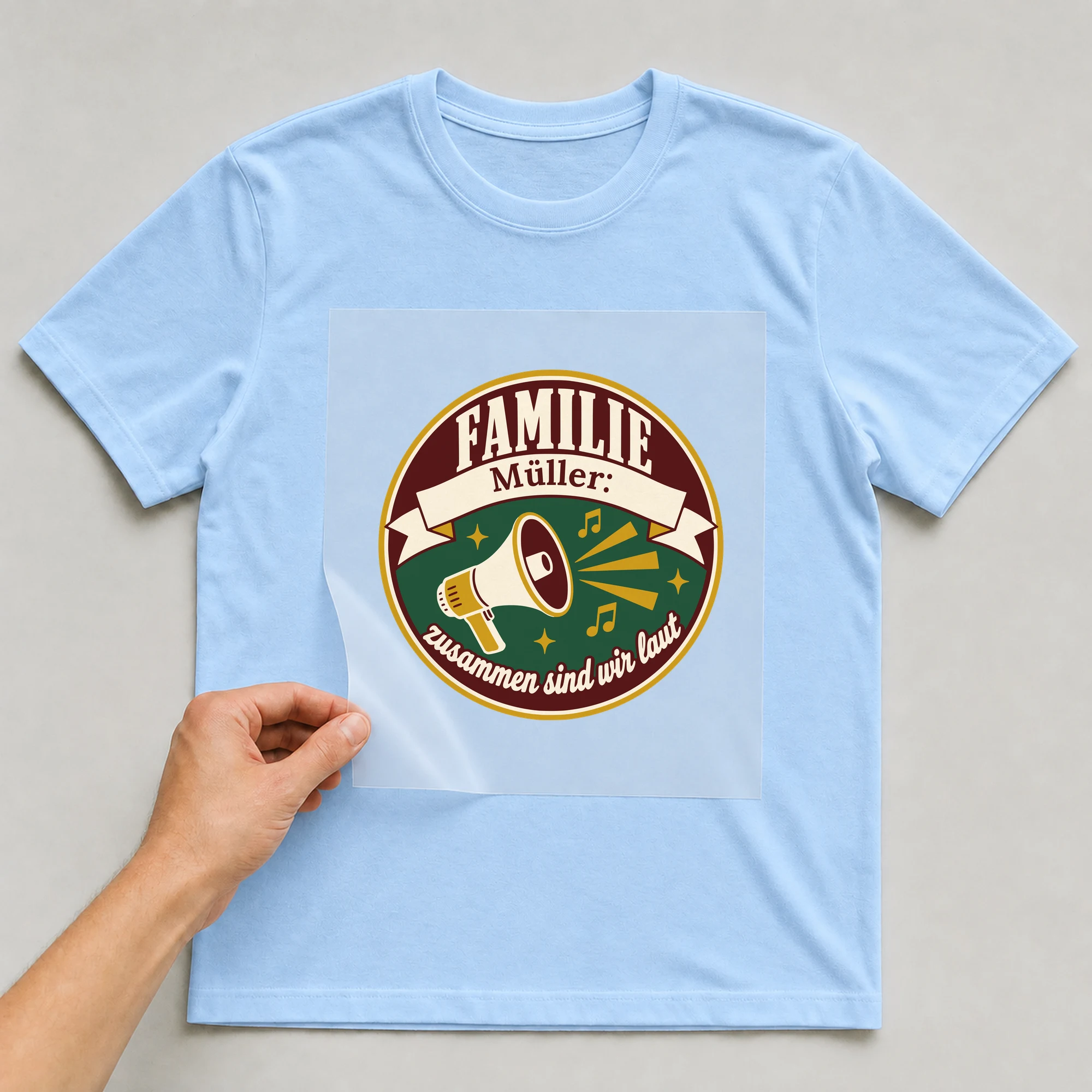 Bügelbild Familie: zusammen sind wir laut mit Nachname auf hellblauem T-Shirt, Folie wird aufgelegt