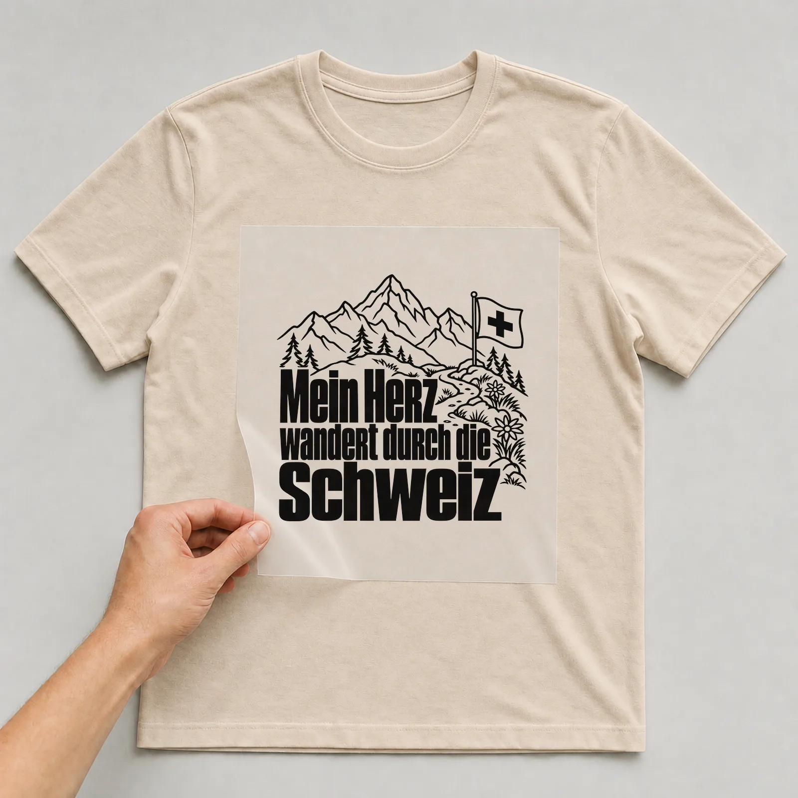 Bügelbild „Mein Herz wandert durch die Schweiz“ auf beigem T-Shirt, Folie wird aufgelegt