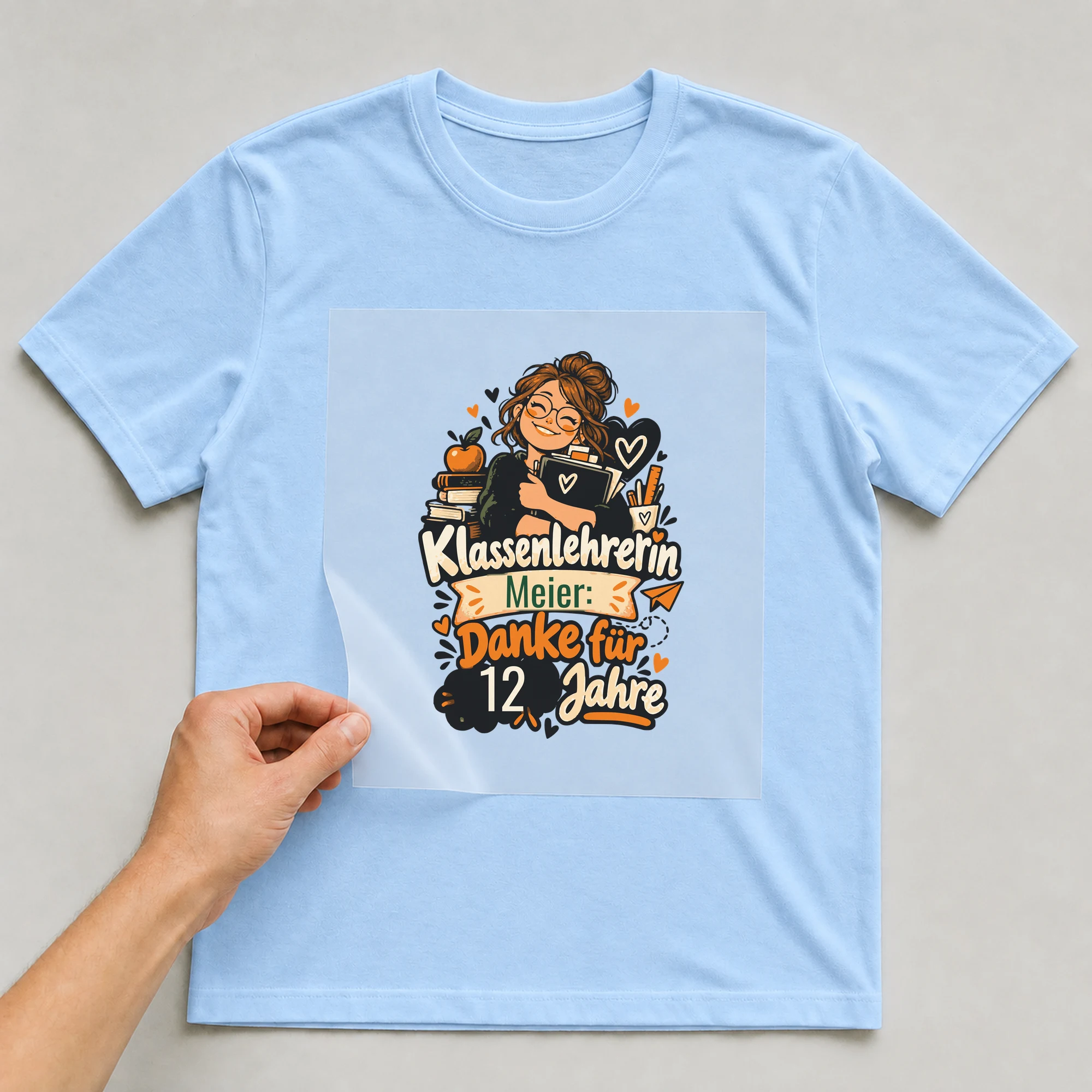 Bügelbild Danke, Klassenlehrerin mit Name und Zahl auf hellblauem T-Shirt, Folie wird aufgelegt