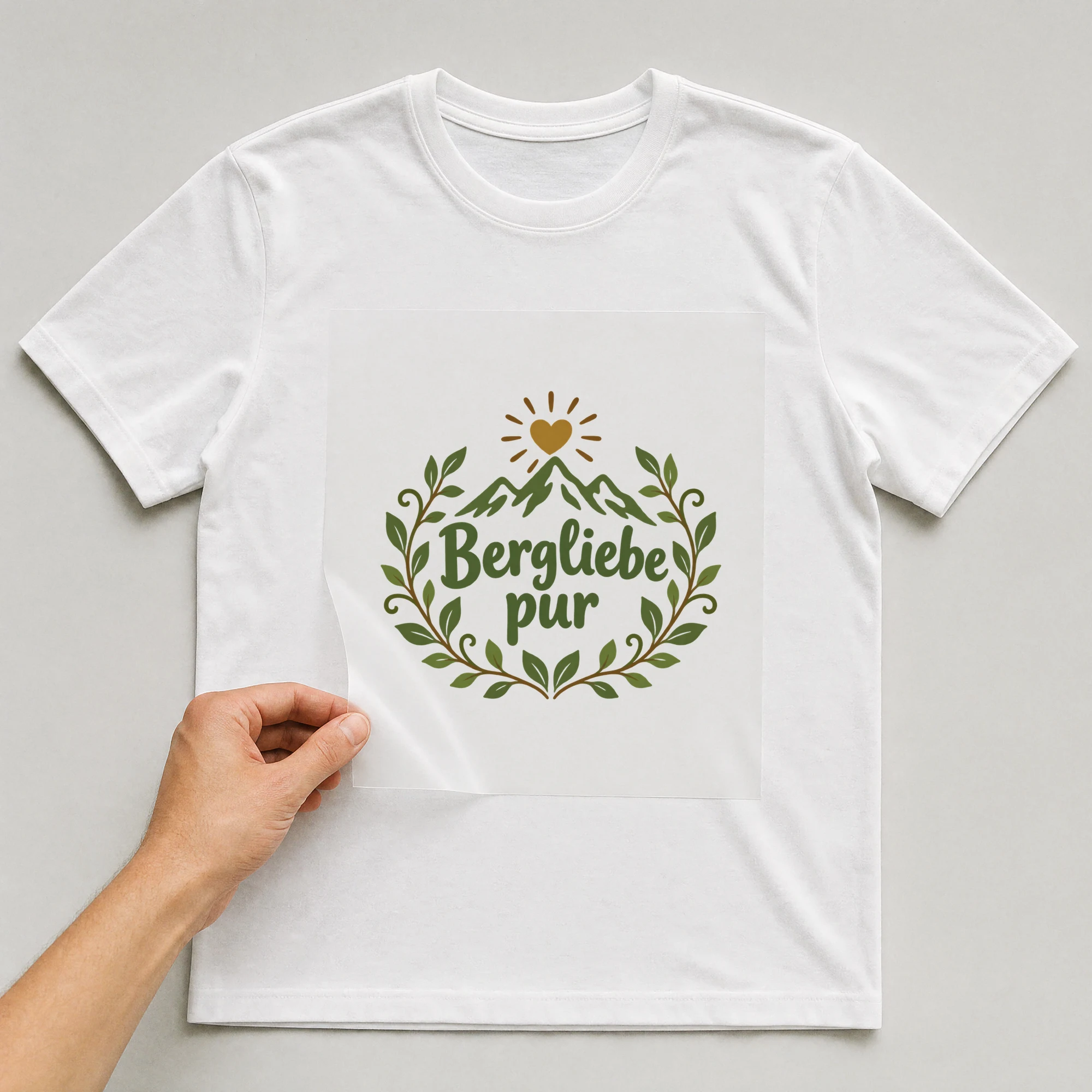 Bügelbild „Bergliebe pur“ auf weißem T-Shirt, Folie wird aufgelegt