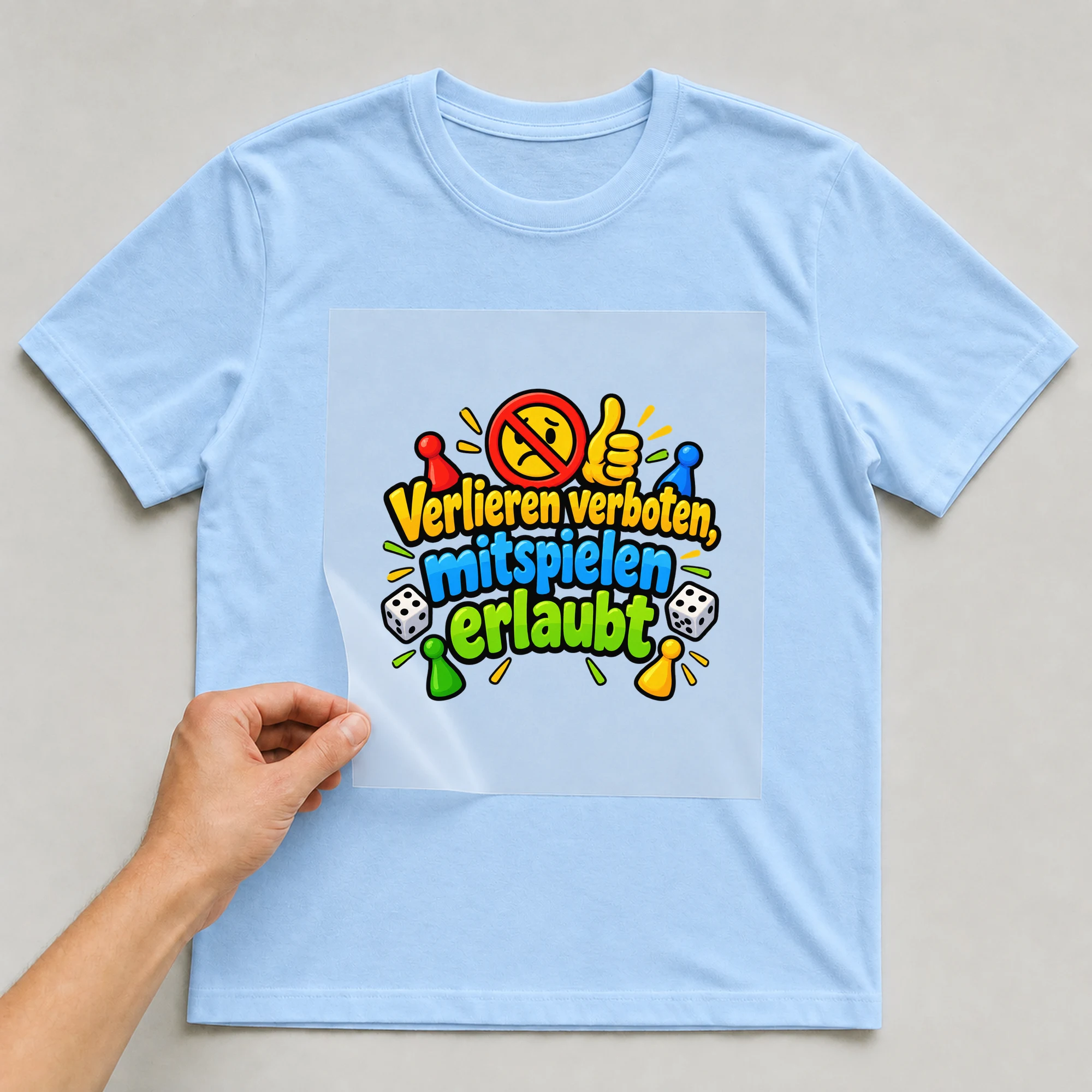 Bügelbild „Verlieren verboten, mitspielen erlaubt“ auf babyblauem T-Shirt, Folie wird aufgelegt