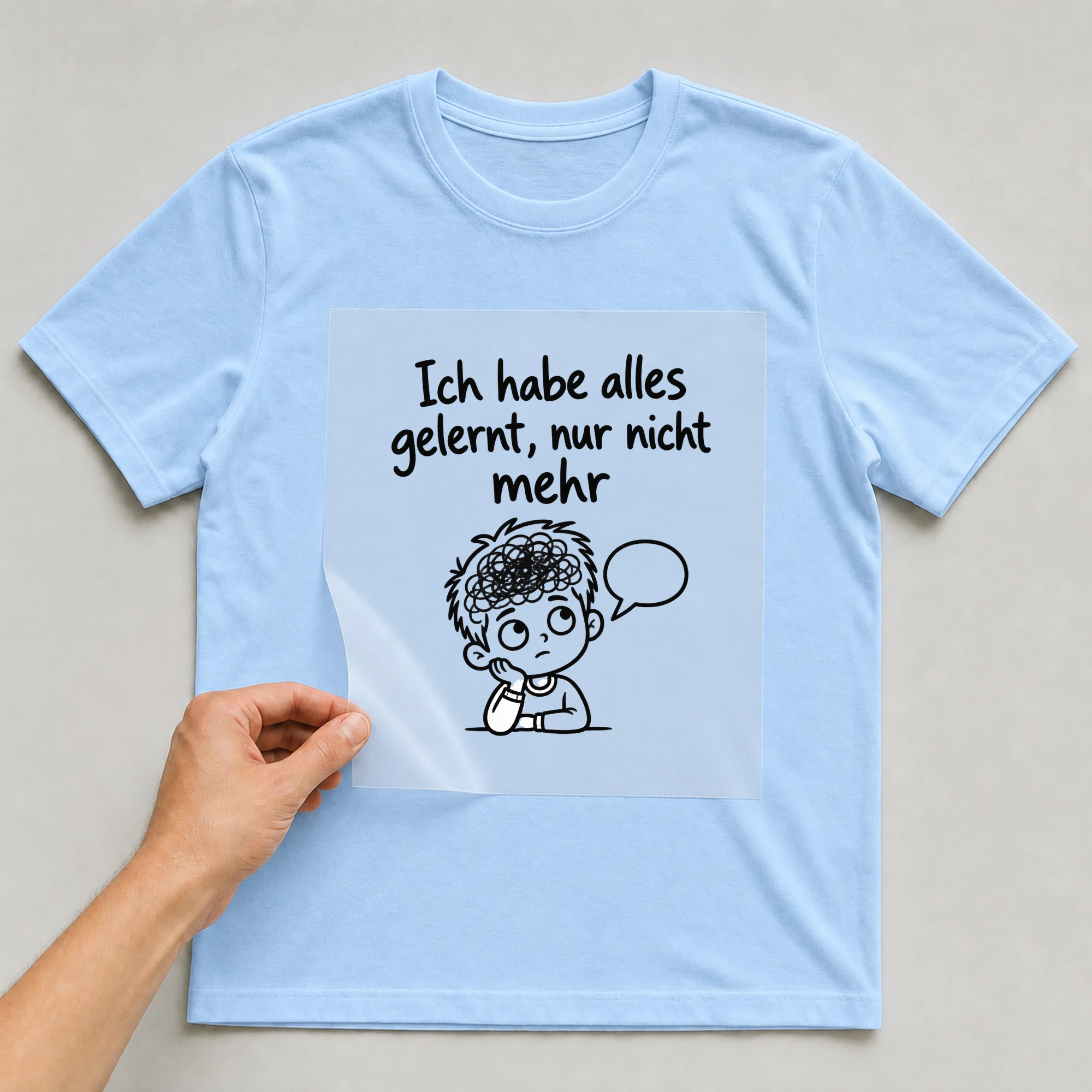 Bügelbild „Ich habe alles gelernt, nur nicht mehr“ auf babyblauem T-Shirt, Folie wird aufgelegt