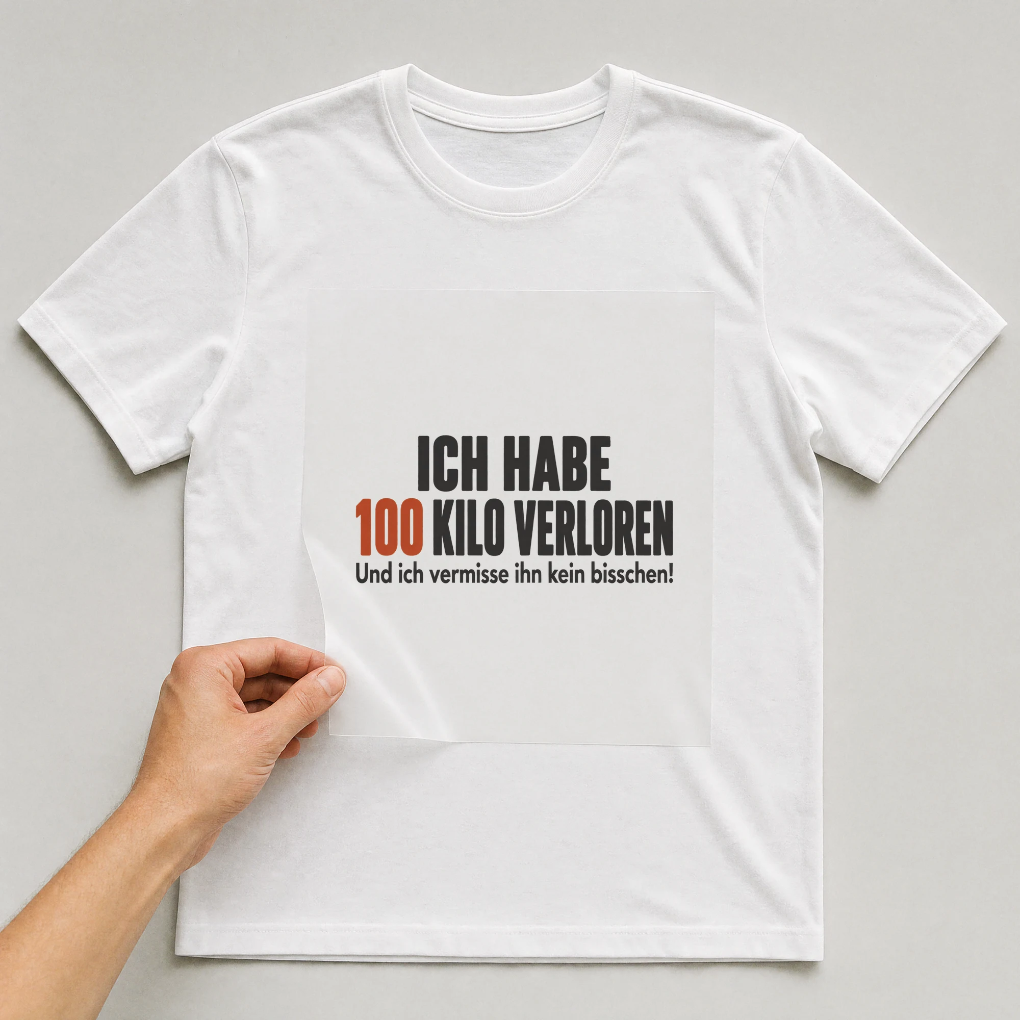 Bügelbild „ICH HABE 100 KILO VERLOREN Und ich vermisse ihn kein bisschen!“ auf weißem T-Shirt, Folie wird aufgelegt