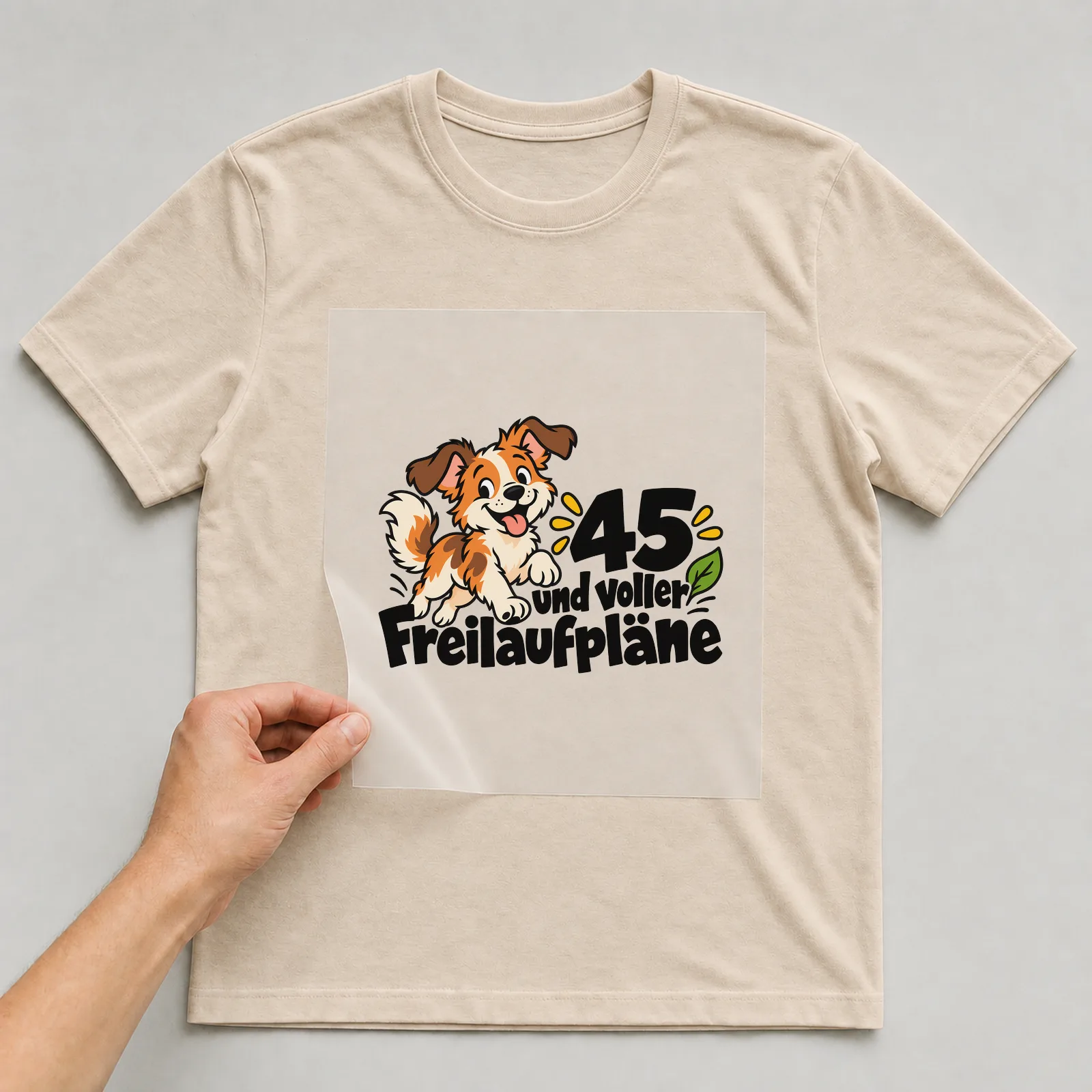 Bügelbild „45 und voller Freilaufpläne“ auf beigem T-Shirt, Folie wird aufgelegt
