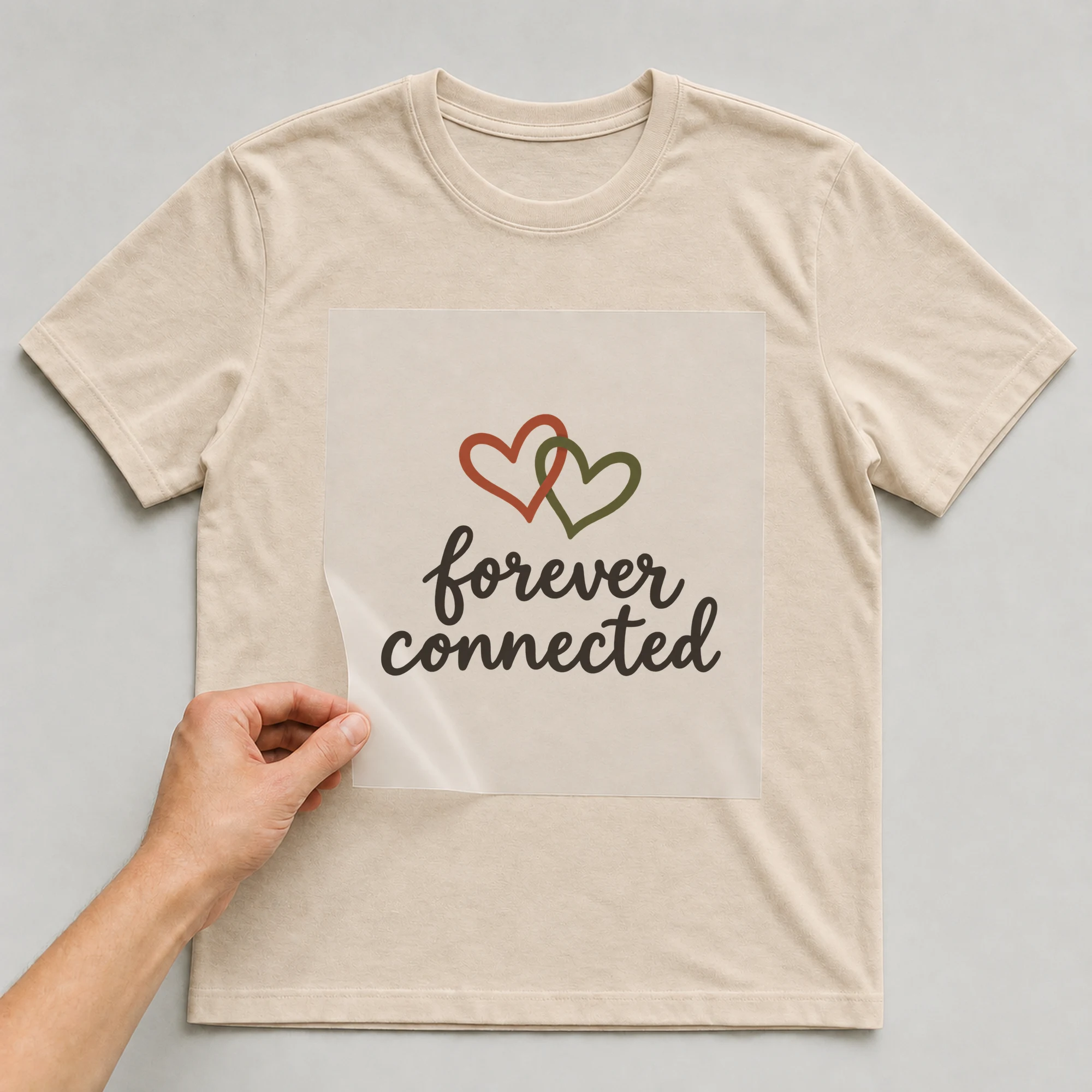 Bügelbild „forever connected“ auf beigem T-Shirt, Folie wird aufgelegt