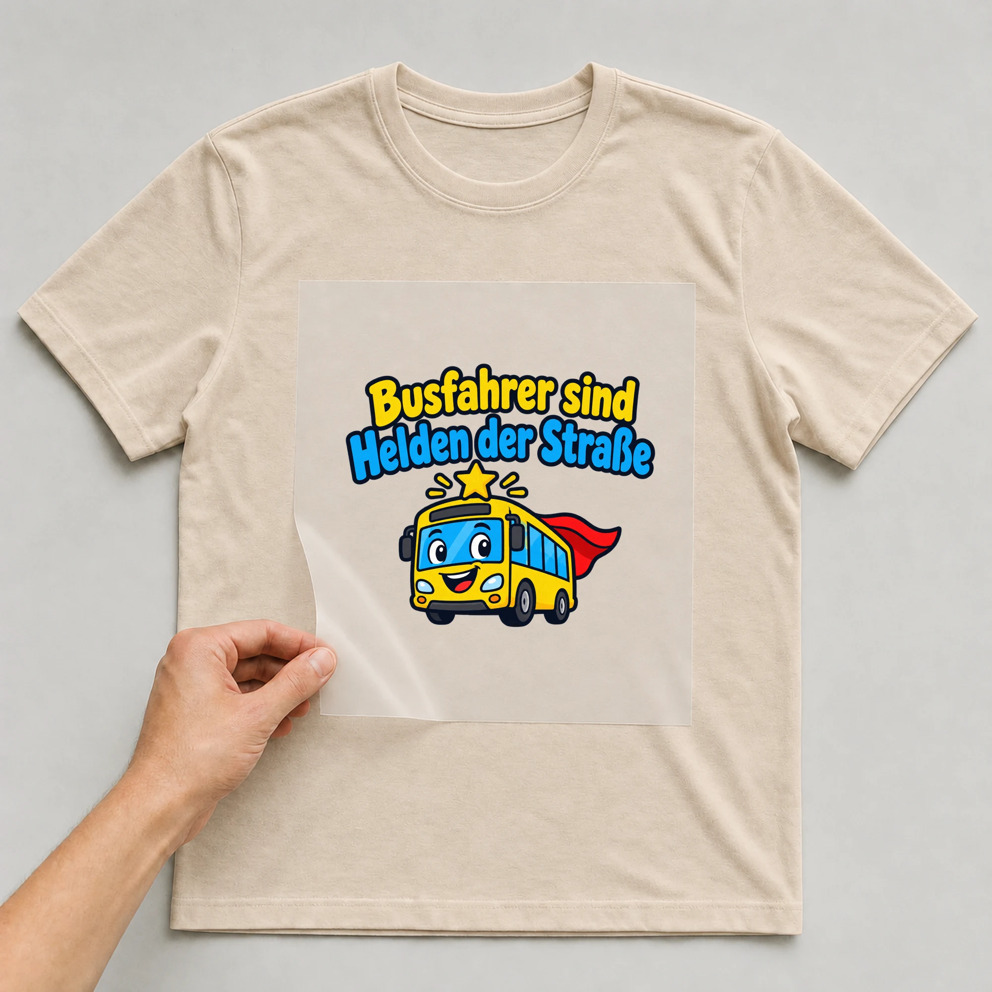 Bügelbild „Busfahrer sind Helden der Straße“ auf beigem T-Shirt, Folie wird aufgelegt