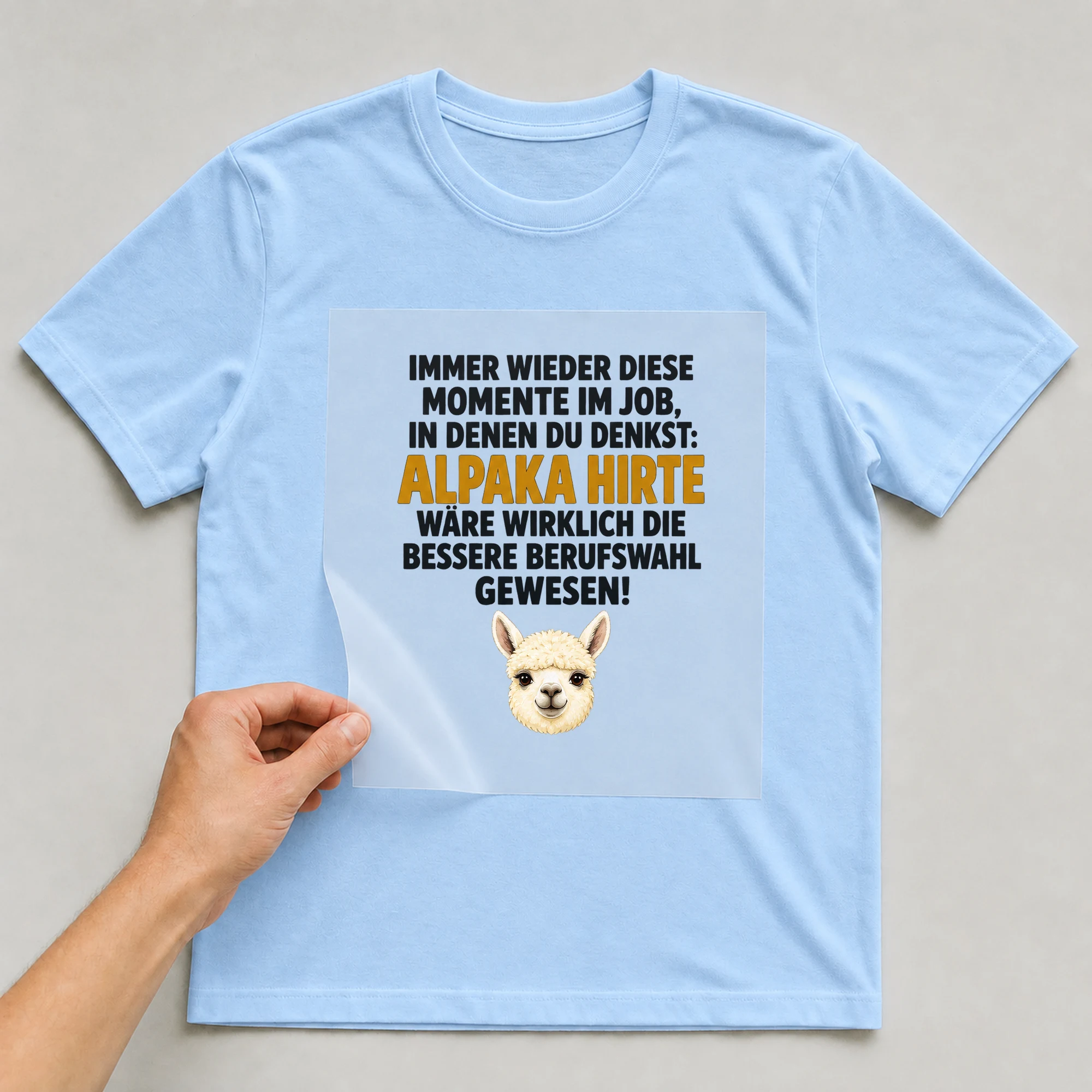 Bügelbild „Immer wieder diese Momente im Job, in denen du denkst“ auf babyblauem T-Shirt, Folie wird aufgelegt