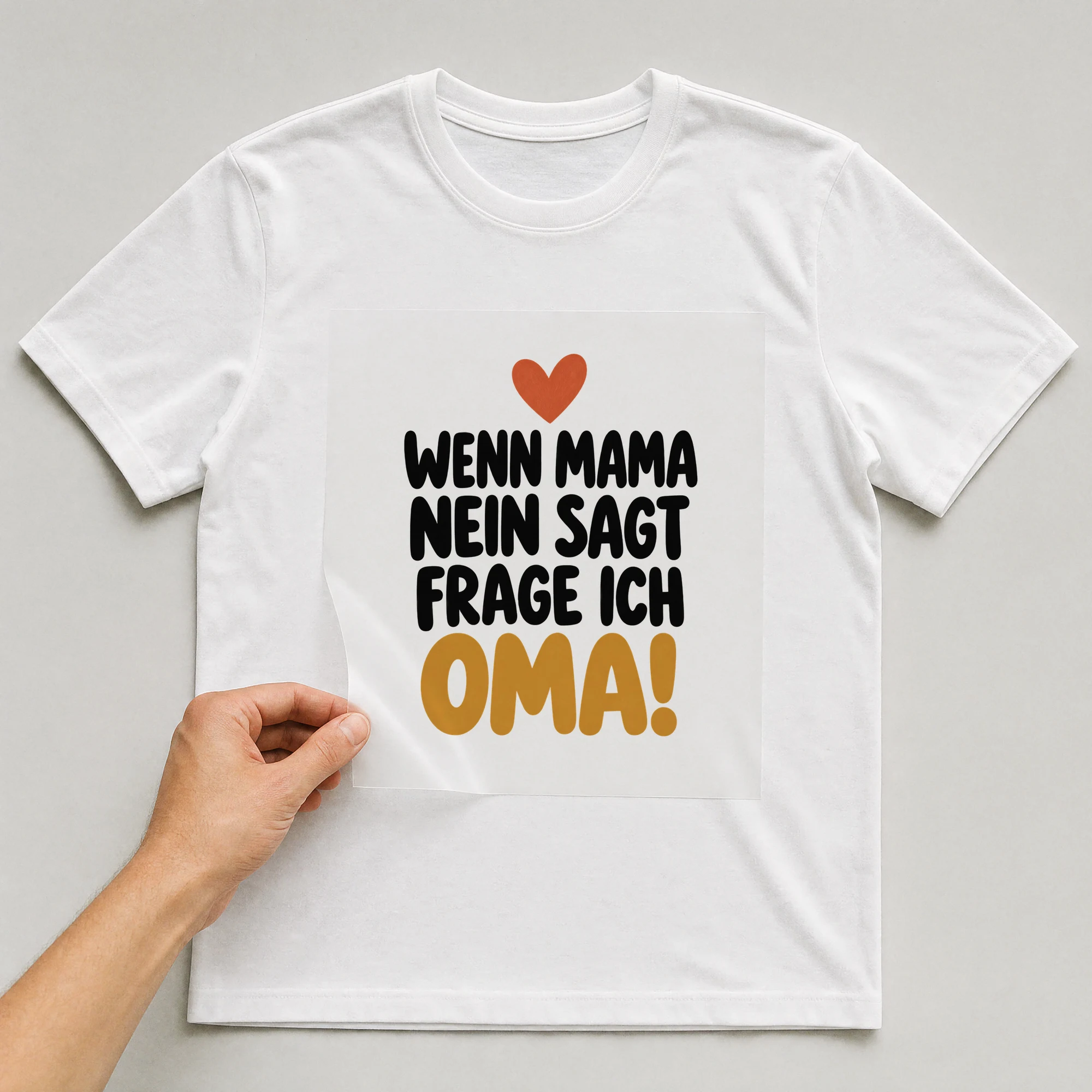 Bügelbild „Wenn Mama nein sagt Frage ich Oma!“ auf weißem T-Shirt, Folie wird aufgelegt