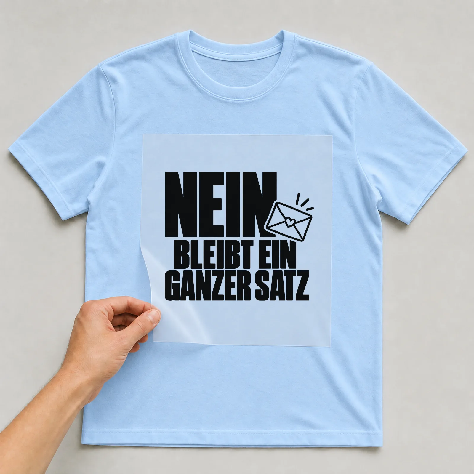 Bügelbild „Nein bleibt ein ganzer Satz“ auf hellblauem T-Shirt, Folie wird aufgelegt