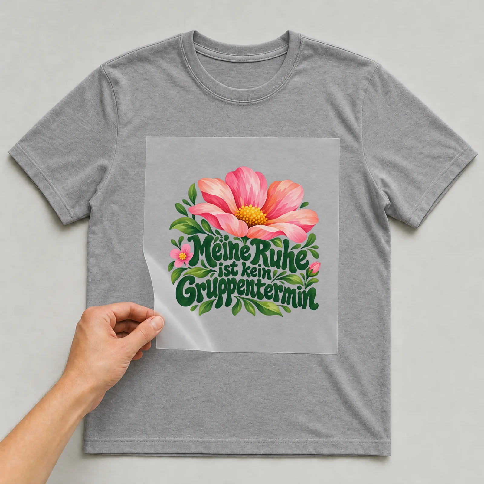 Bügelbild „Meine Ruhe ist kein Gruppentermin“ auf grauem T-Shirt, Folie wird aufgelegt