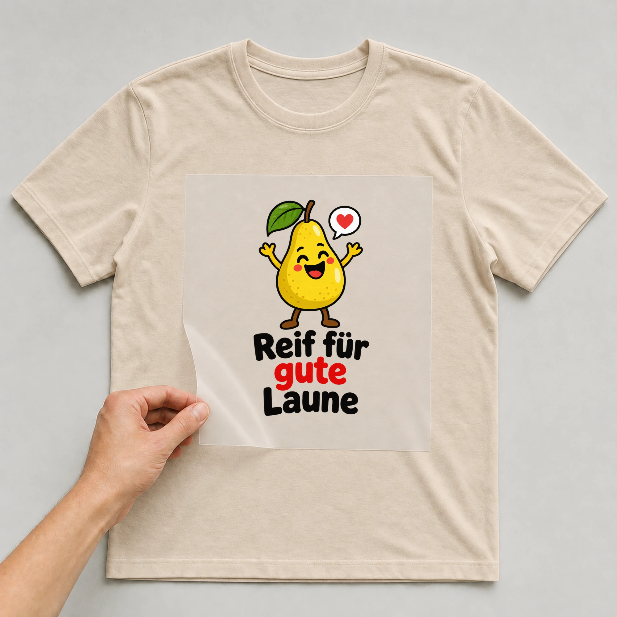 Bügelbild „Birne macht glücklich“ auf beigem T-Shirt, Folie wird aufgelegt