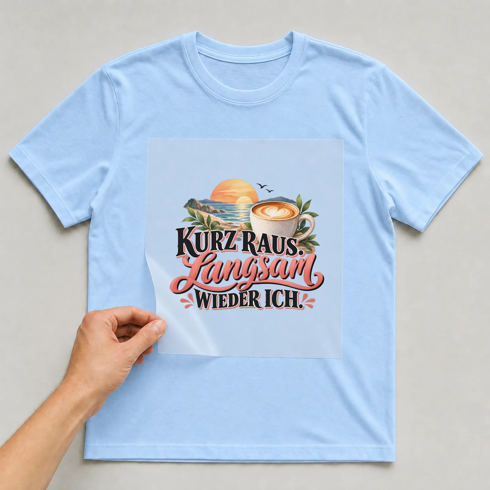 Bügelbild „Kurz raus. Langsam wieder ich.“ auf hellblauem T-Shirt, Folie wird aufgelegt