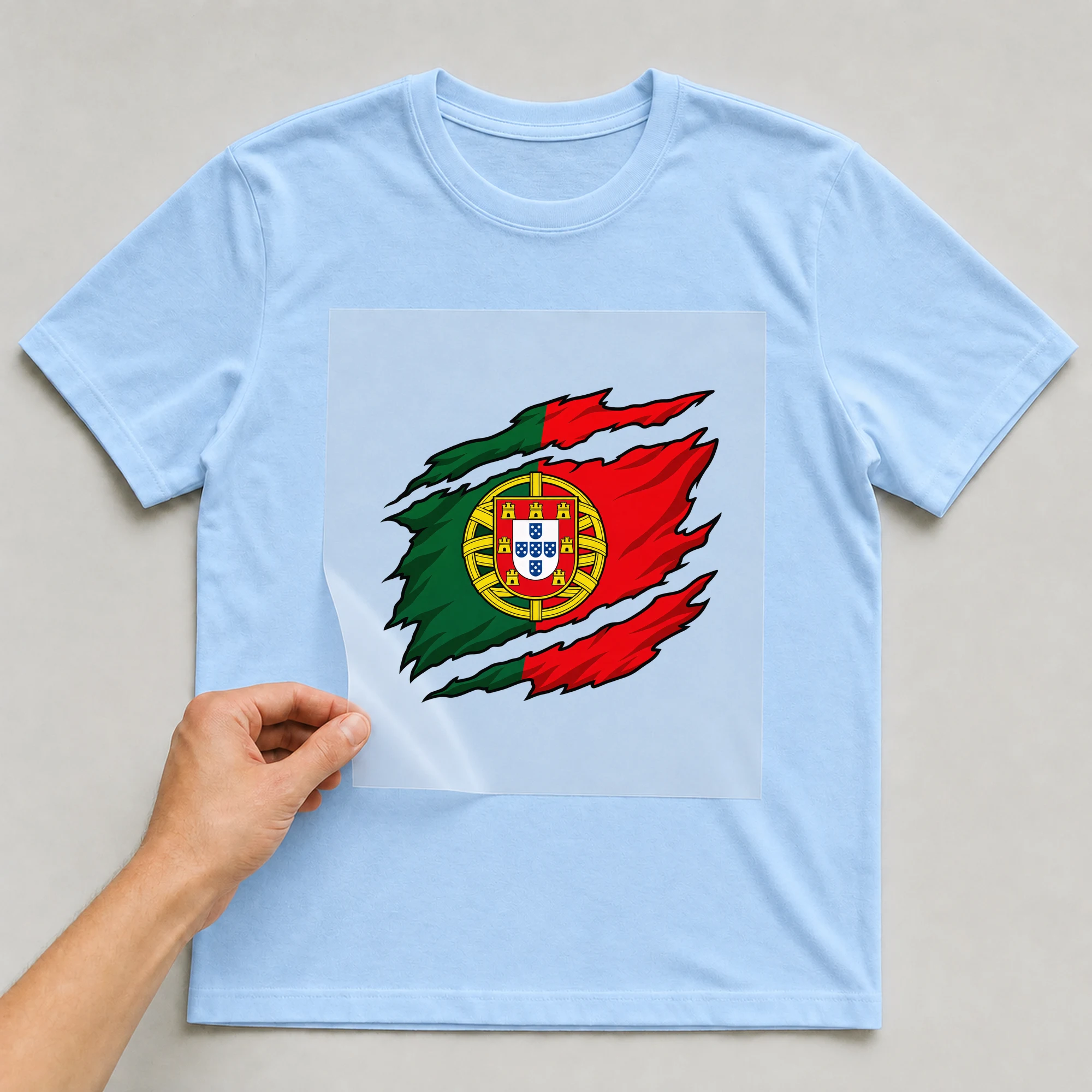 Bügelbild „Zerrissene Fahne Portugal“ auf babyblauem T-Shirt, Folie wird aufgelegt