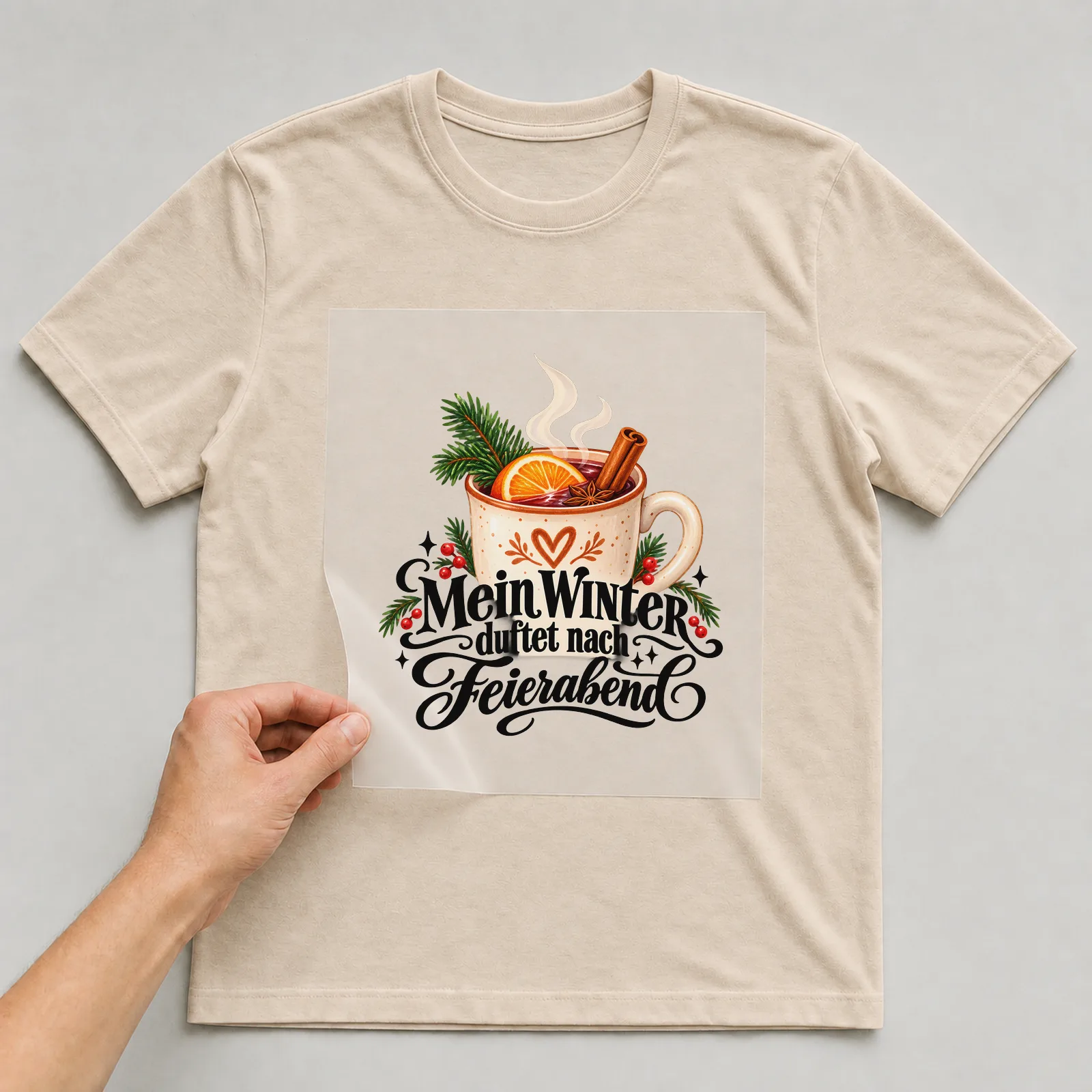 Bügelbild „Mein Winter duftet nach Feierabend“ auf beigem T-Shirt, Folie wird aufgelegt