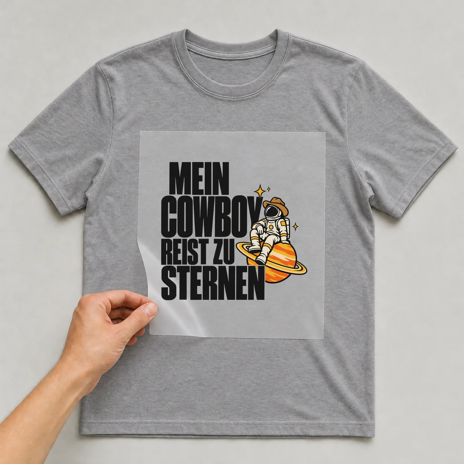Bügelbild „Mein Cowboy reist zu Sternen“ auf grauem T-Shirt, Folie wird aufgelegt