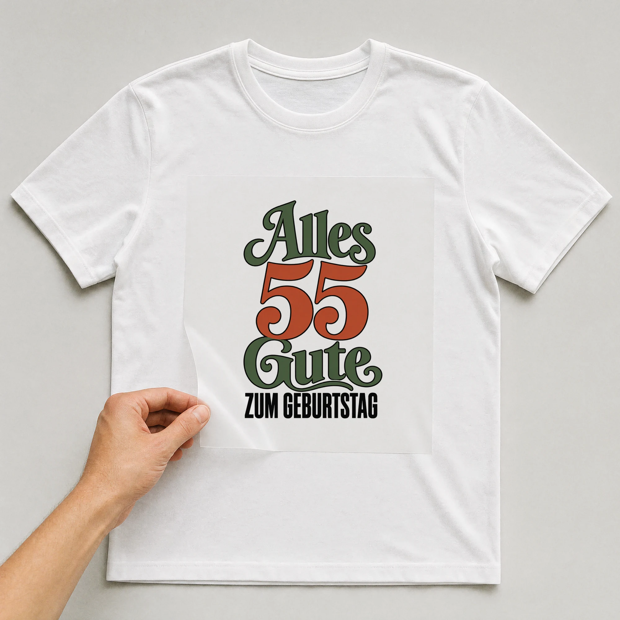 Bügelbild „Alles 55 Gute zum Geburtstag“ auf weißem T-Shirt, Folie wird aufgelegt
