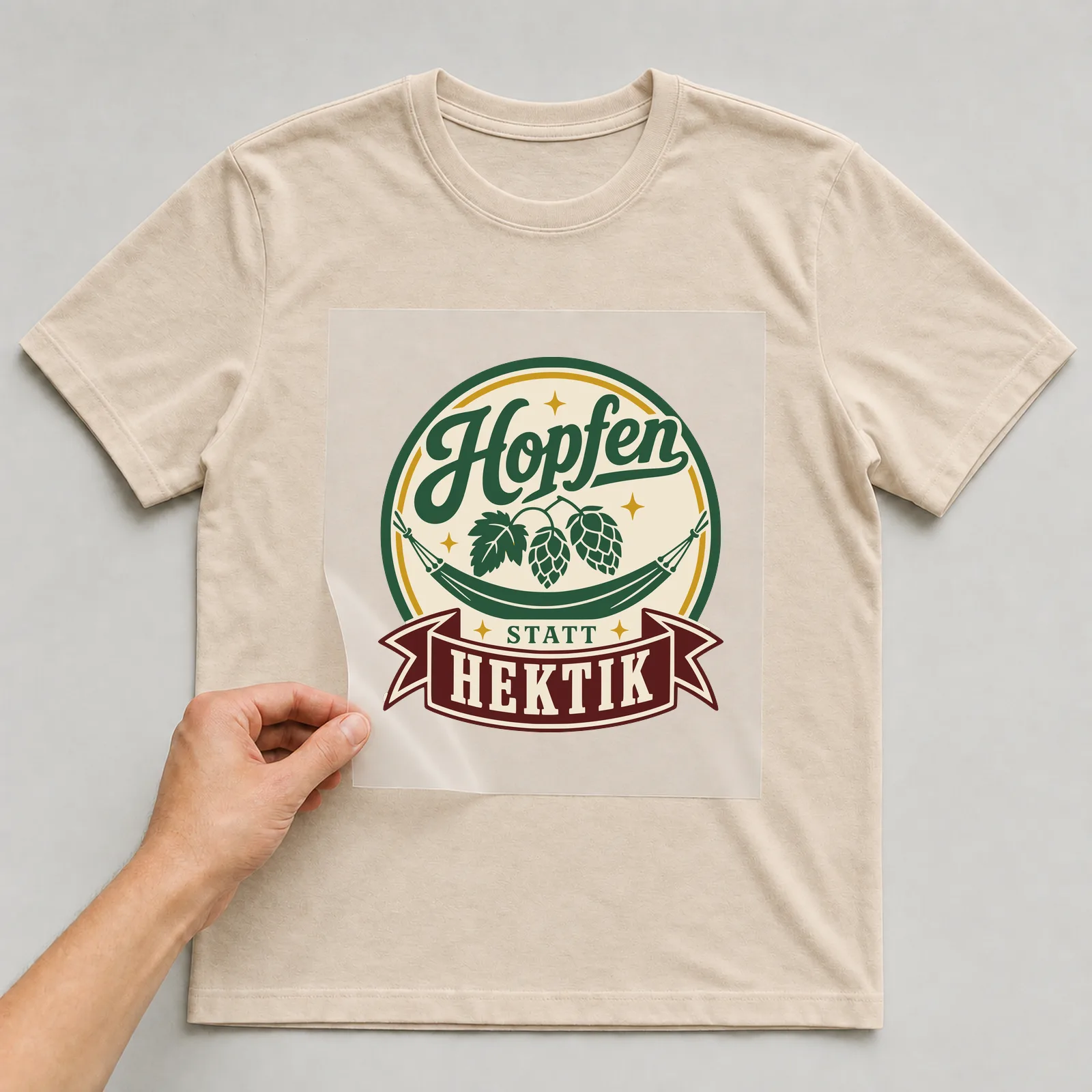 Bügelbild Hopfen statt Hektik auf beigem T-Shirt, Folie wird aufgelegt