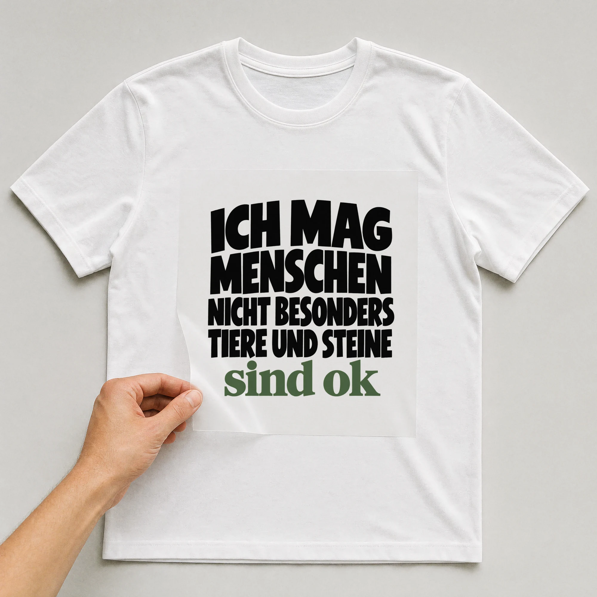 Bügelbild „Ich Mag Menschen Nicht Besonders Tiere Und Steine Sind Ok“ auf weißem T-Shirt, Folie wird aufgelegt