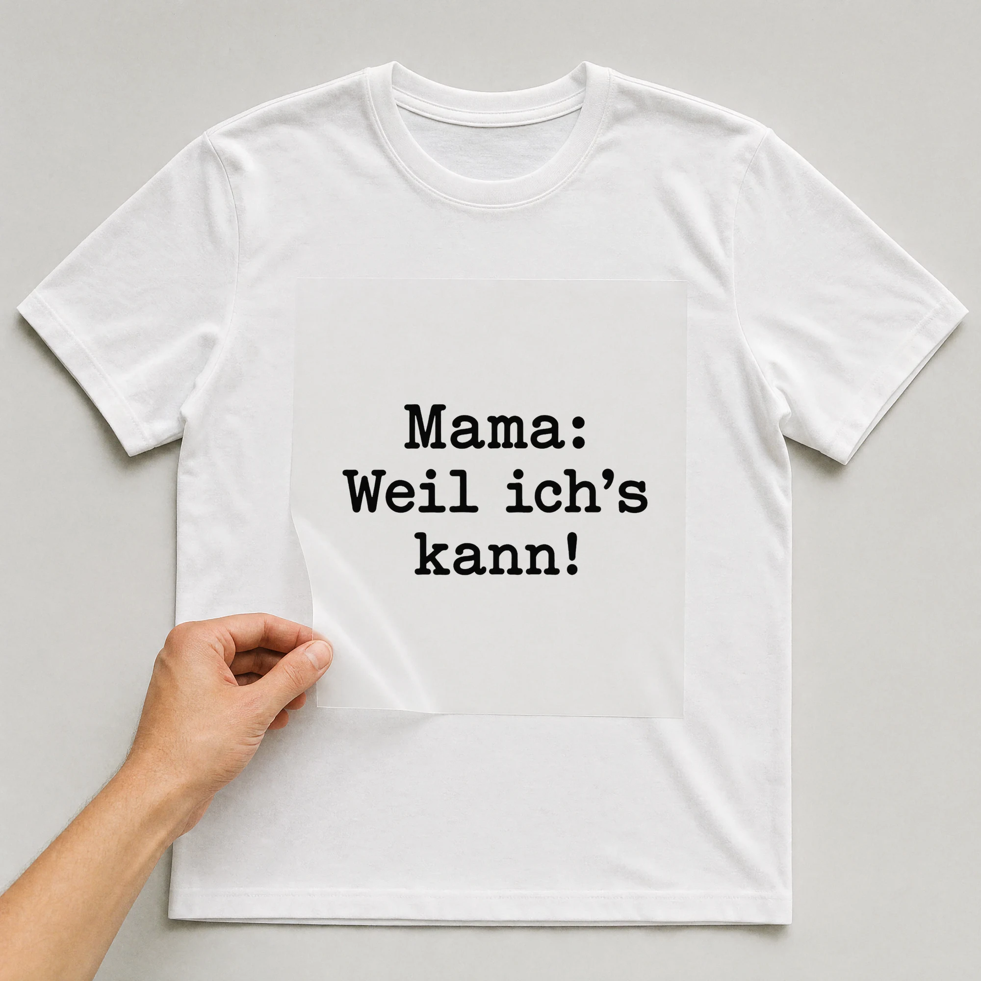 Bügelbild „Mama: Weil ich's kann!“ auf weißem T-Shirt, Folie wird aufgelegt