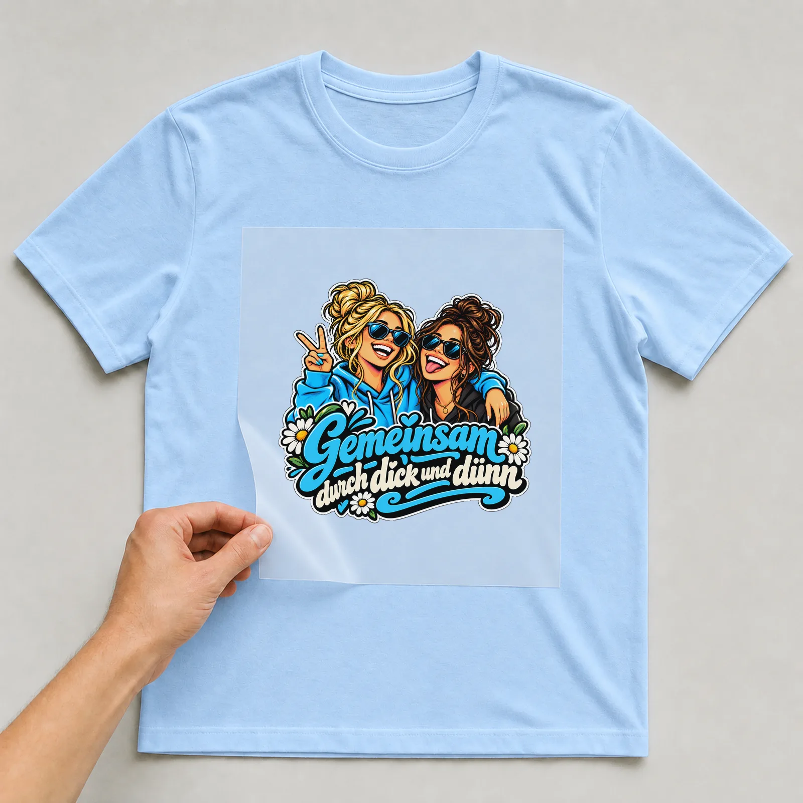 Bügelbild „Gemeinsam durch dick und dünn“ auf hellblauem T-Shirt, Folie wird aufgelegt