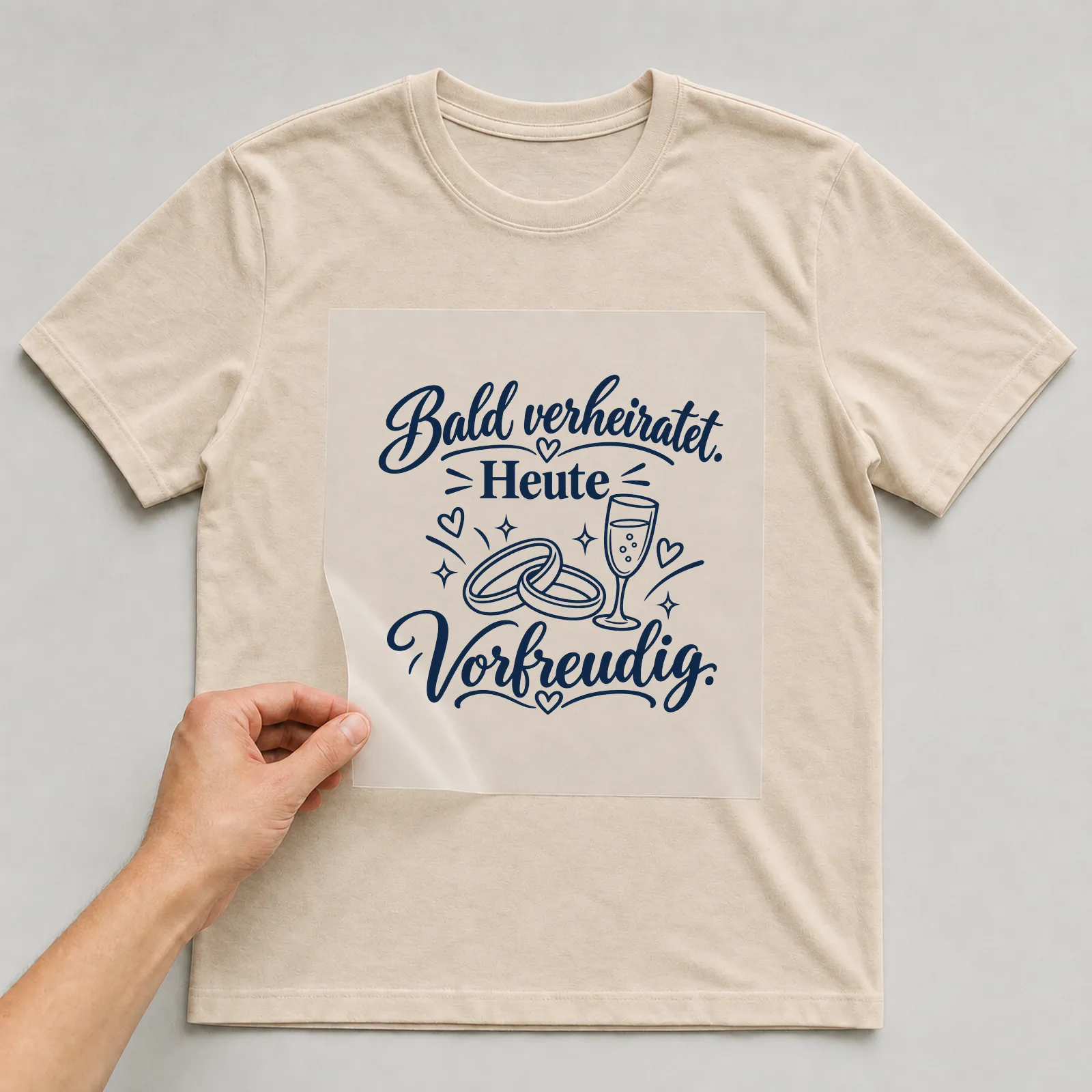 Bügelbild „Bald verheiratet. Heute vorfreudig.“ auf beigem T-Shirt, Folie wird aufgelegt
