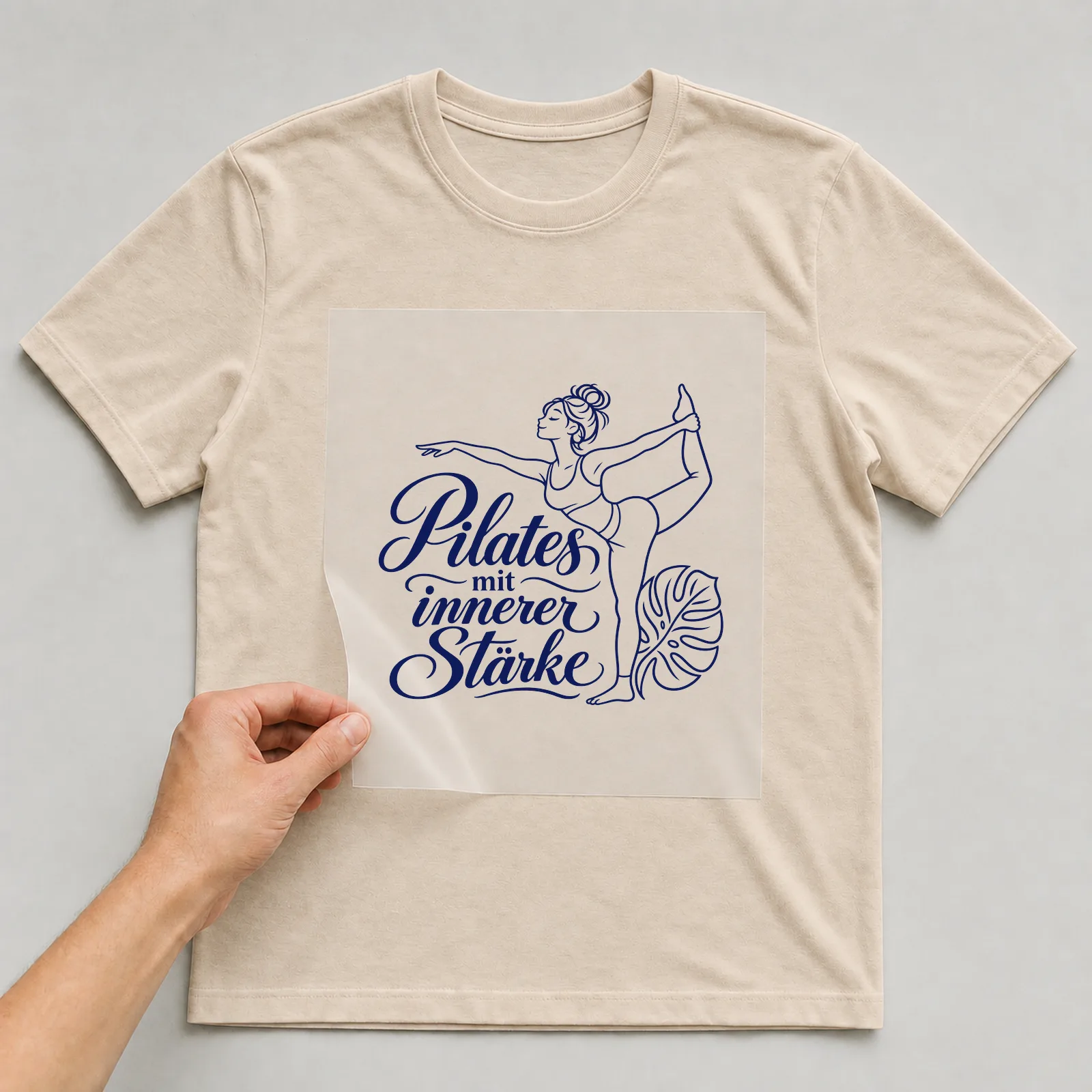 Bügelbild „Pilates mit innerer Stärke“ auf beigem T-Shirt, Folie wird aufgelegt