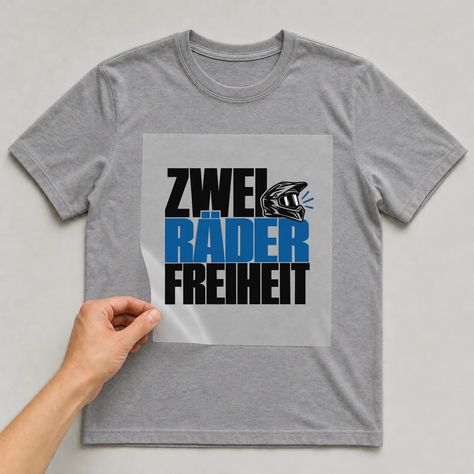 Bügelbild „Zwei Räder Freiheit“ auf grauem T-Shirt, Folie wird aufgelegt