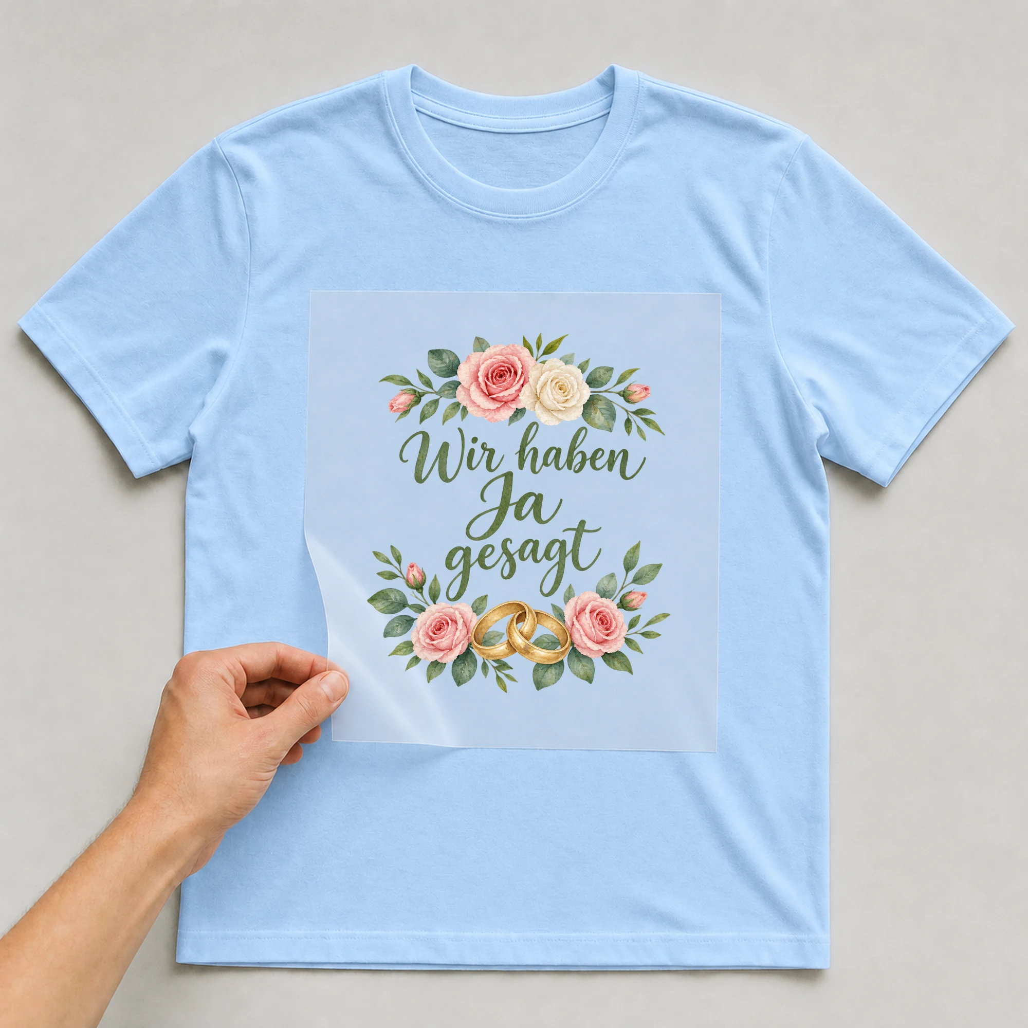 Bügelbild „Wir haben Ja gesagt“ auf babyblauem T-Shirt, Folie wird aufgelegt