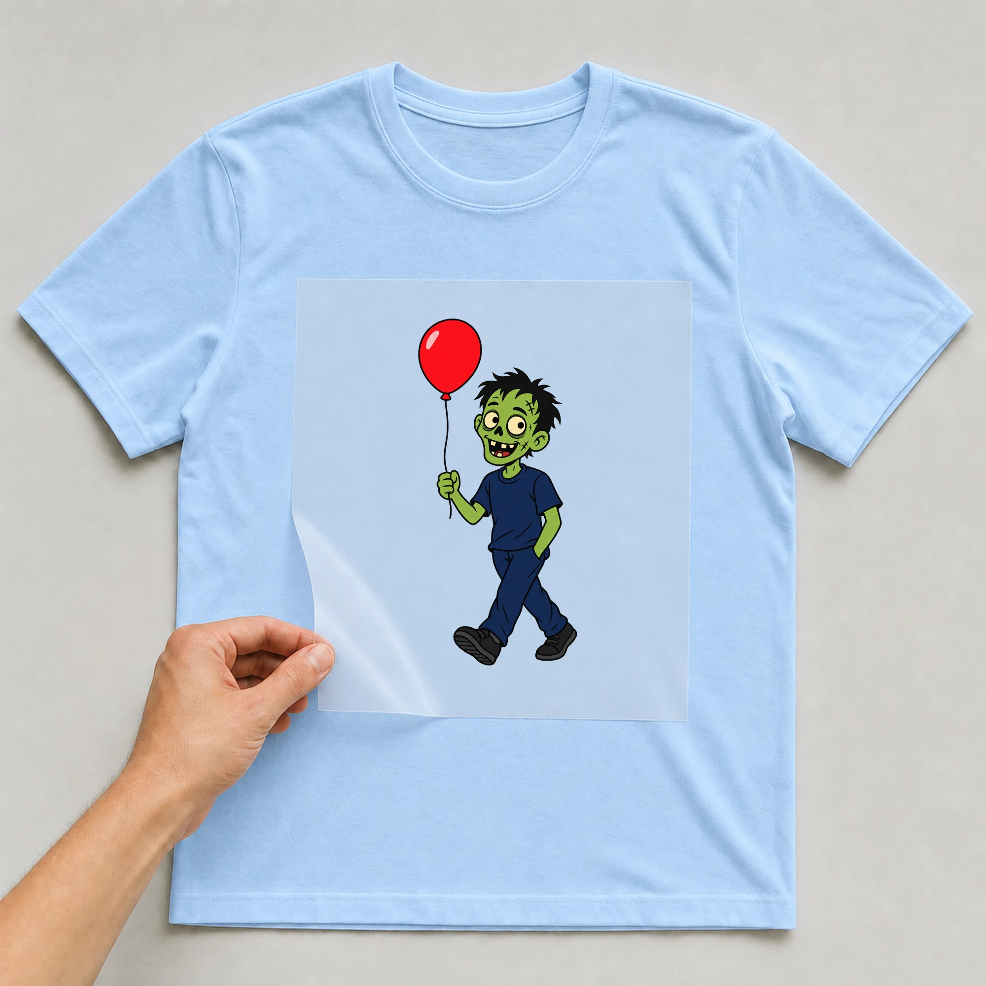 Bügelbild „Zombie Luftballon“ auf babyblauem T-Shirt, Folie wird aufgelegt