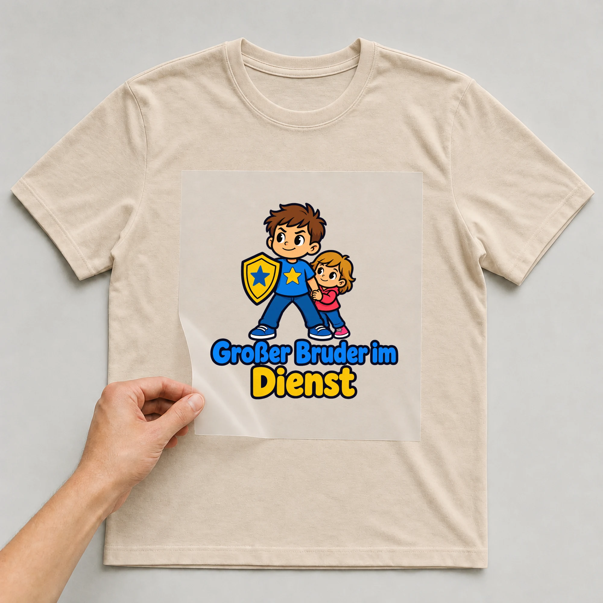 Bügelbild „Großer Bruder im Dienst“ auf beigem T-Shirt, Folie wird aufgelegt