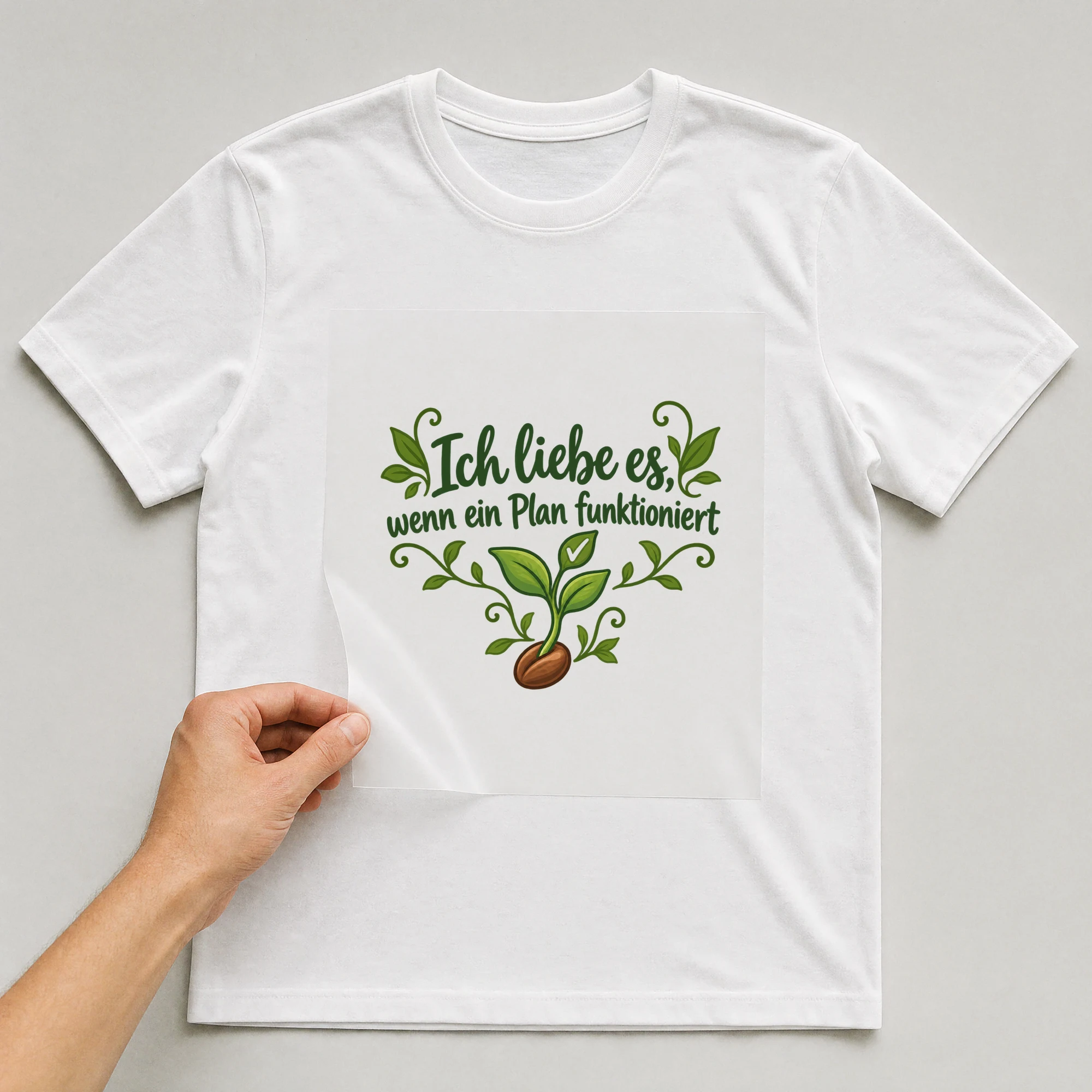 Bügelbild „Ich liebe es, wenn ein Plan funktioniert“ auf weißem T-Shirt, Folie wird aufgelegt