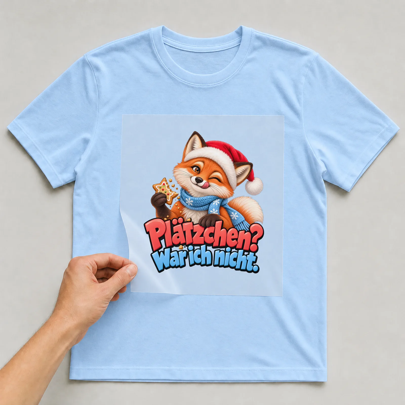 Bügelbild „Plätzchen? War ich nicht.“ auf hellblauem T-Shirt, Folie wird aufgelegt