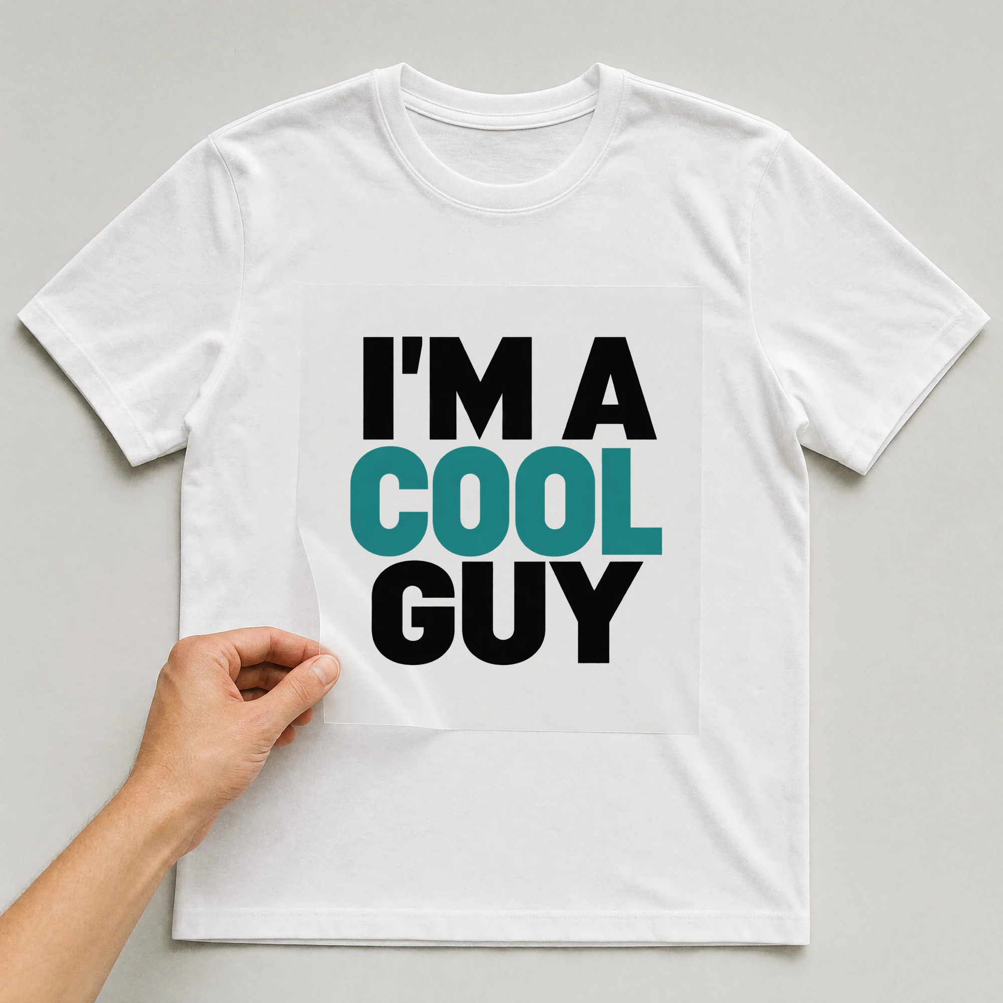 Bügelbild „I'm A Cool Guy“ auf weißem T-Shirt, Folie wird aufgelegt