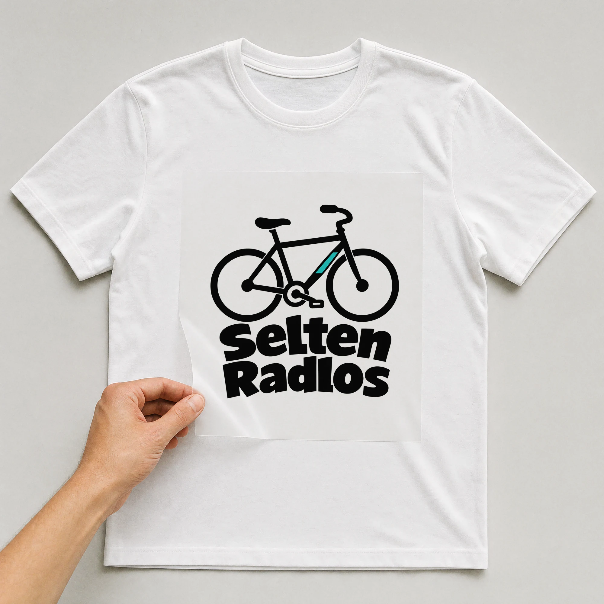 Bügelbild „Selten Radlos“ auf weißem T-Shirt, Folie wird aufgelegt