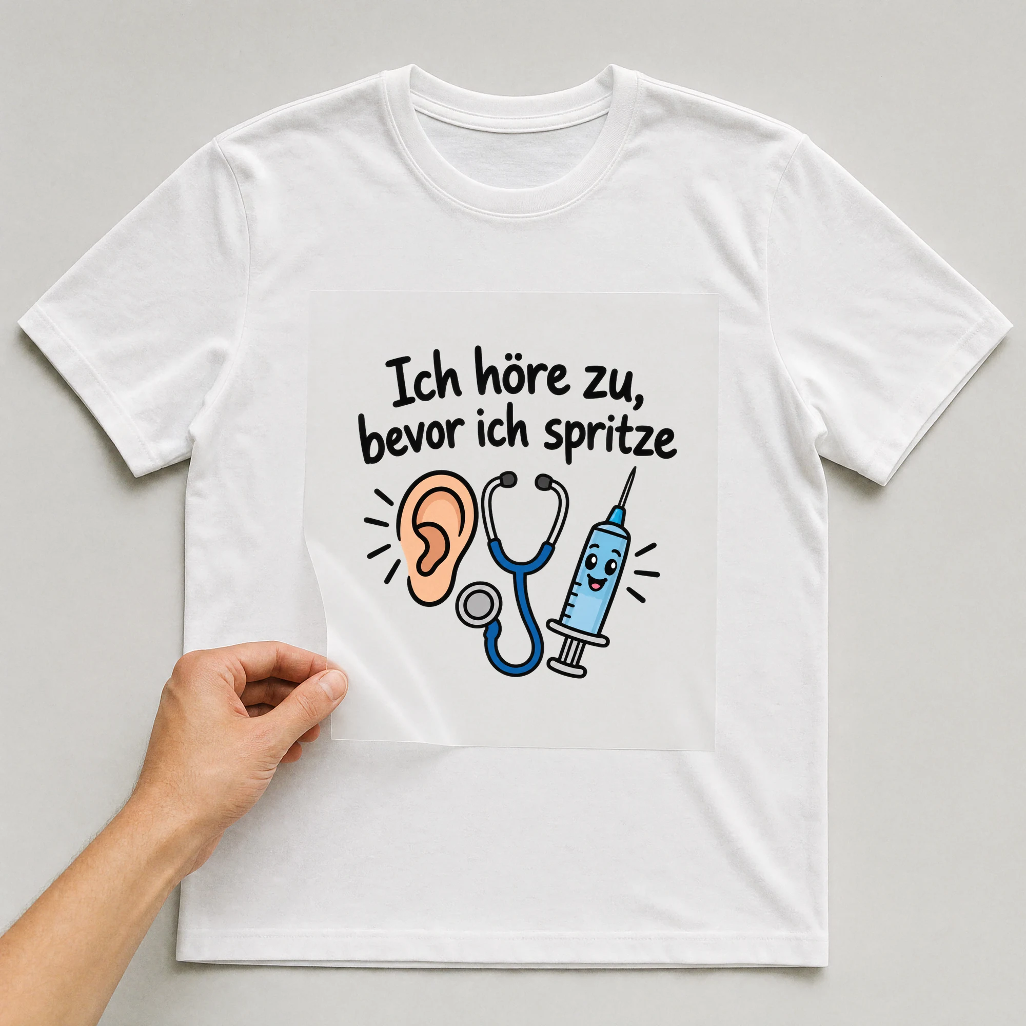 Bügelbild „Ich höre zu, bevor ich spritze“ auf weißem T-Shirt, Folie wird aufgelegt