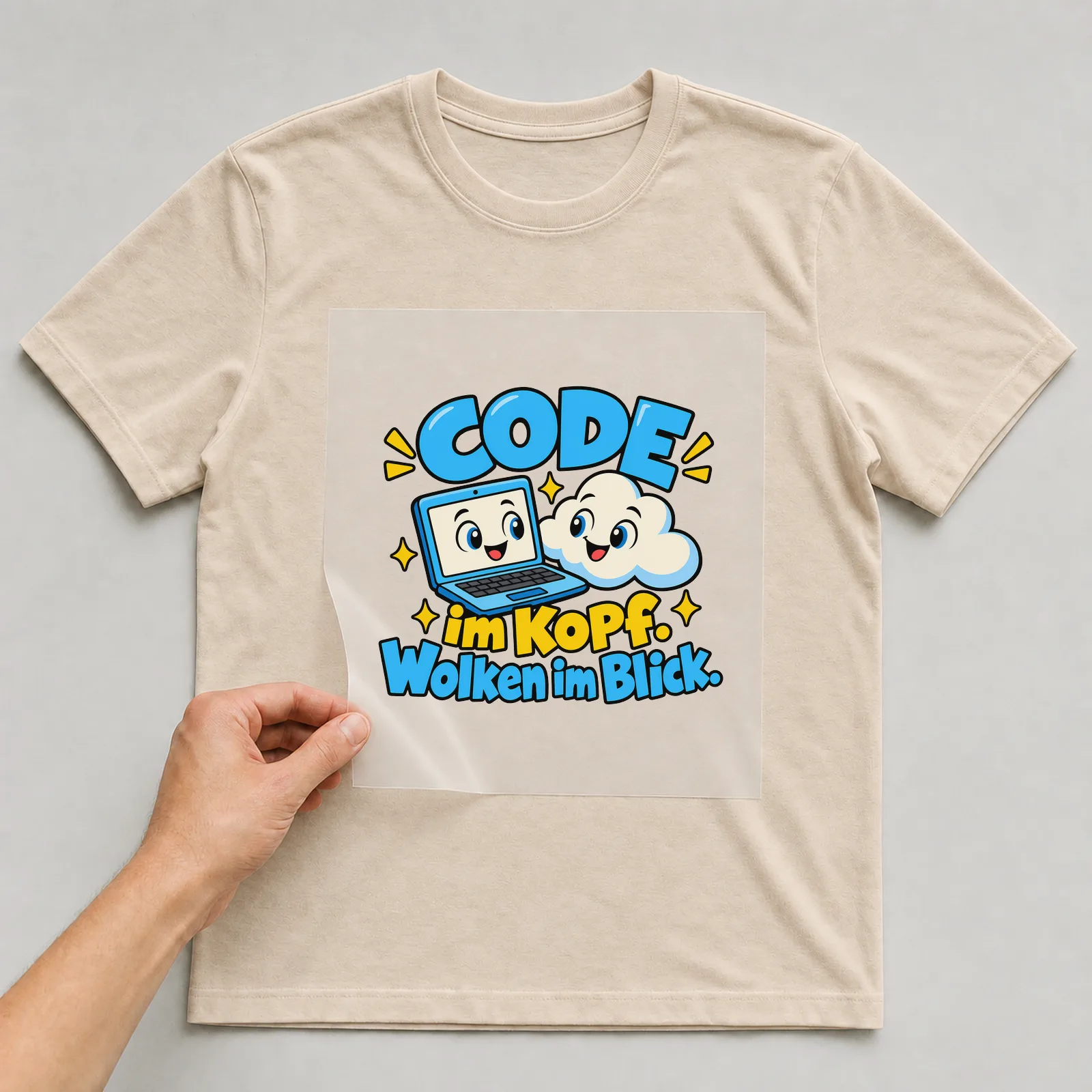 Bügelbild „Code im Kopf. Wolken im Blick.“ auf beigem T-Shirt, Folie wird aufgelegt