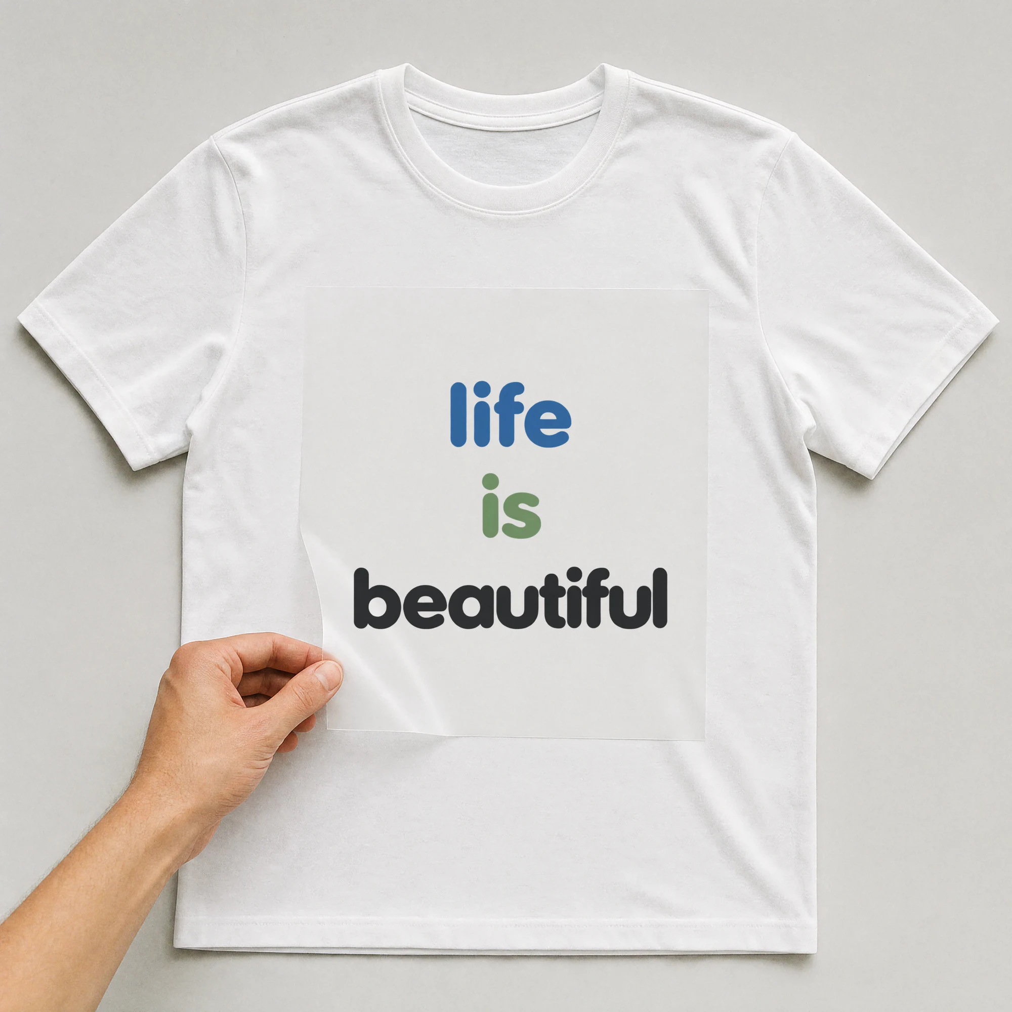 Bügelbild „life is beautiful“ auf weißem T-Shirt, Folie wird aufgelegt