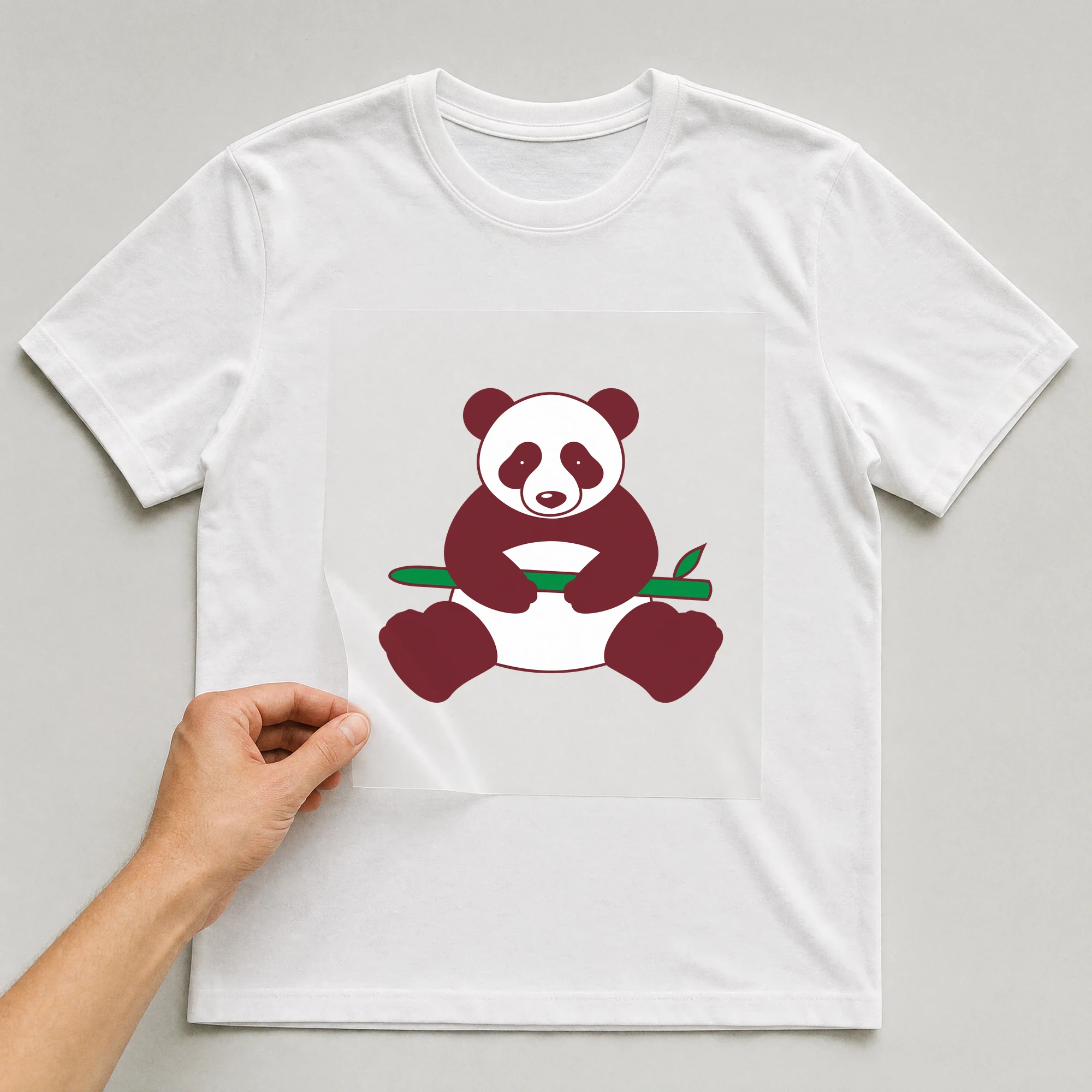 Bügelbild „Panda mit Bambus“ auf weißem T-Shirt, Folie wird aufgelegt