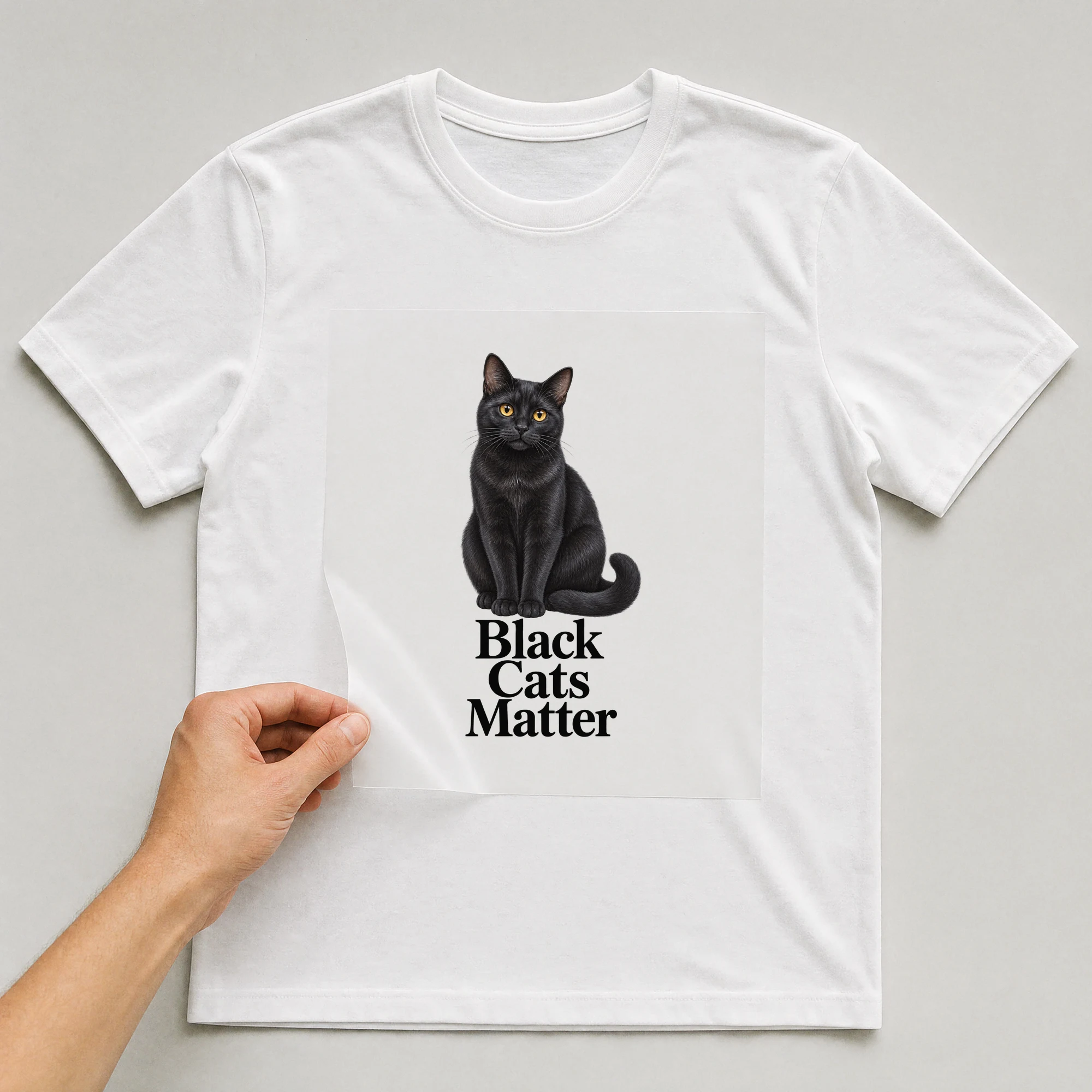 Bügelbild „Black Cats Matter“ auf weißem T-Shirt, Folie wird aufgelegt